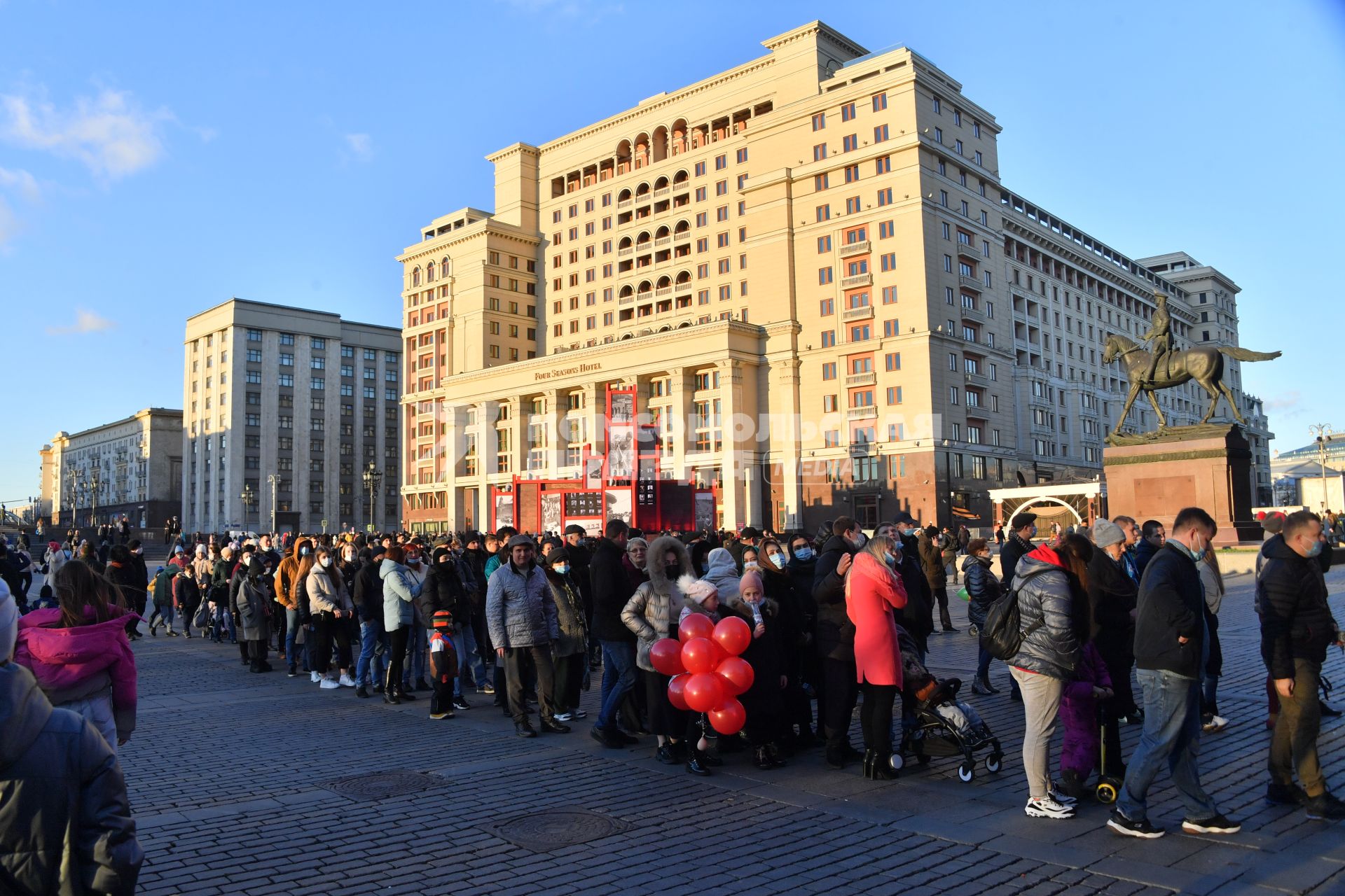 Москва.  Люди стоят в очереди на Манежной площади.