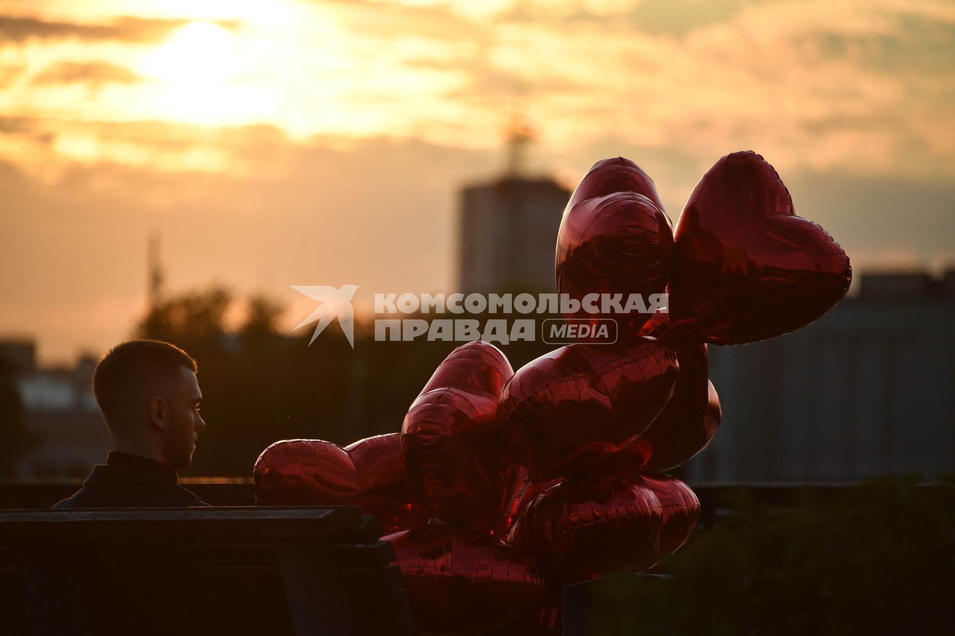 Москва.  Молодой человек с воздушными шарами в виде сердца.