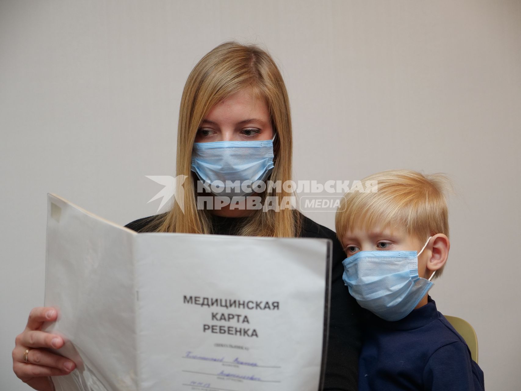 Самара.  Девушка держит в руке медицинскую карту ребенка.