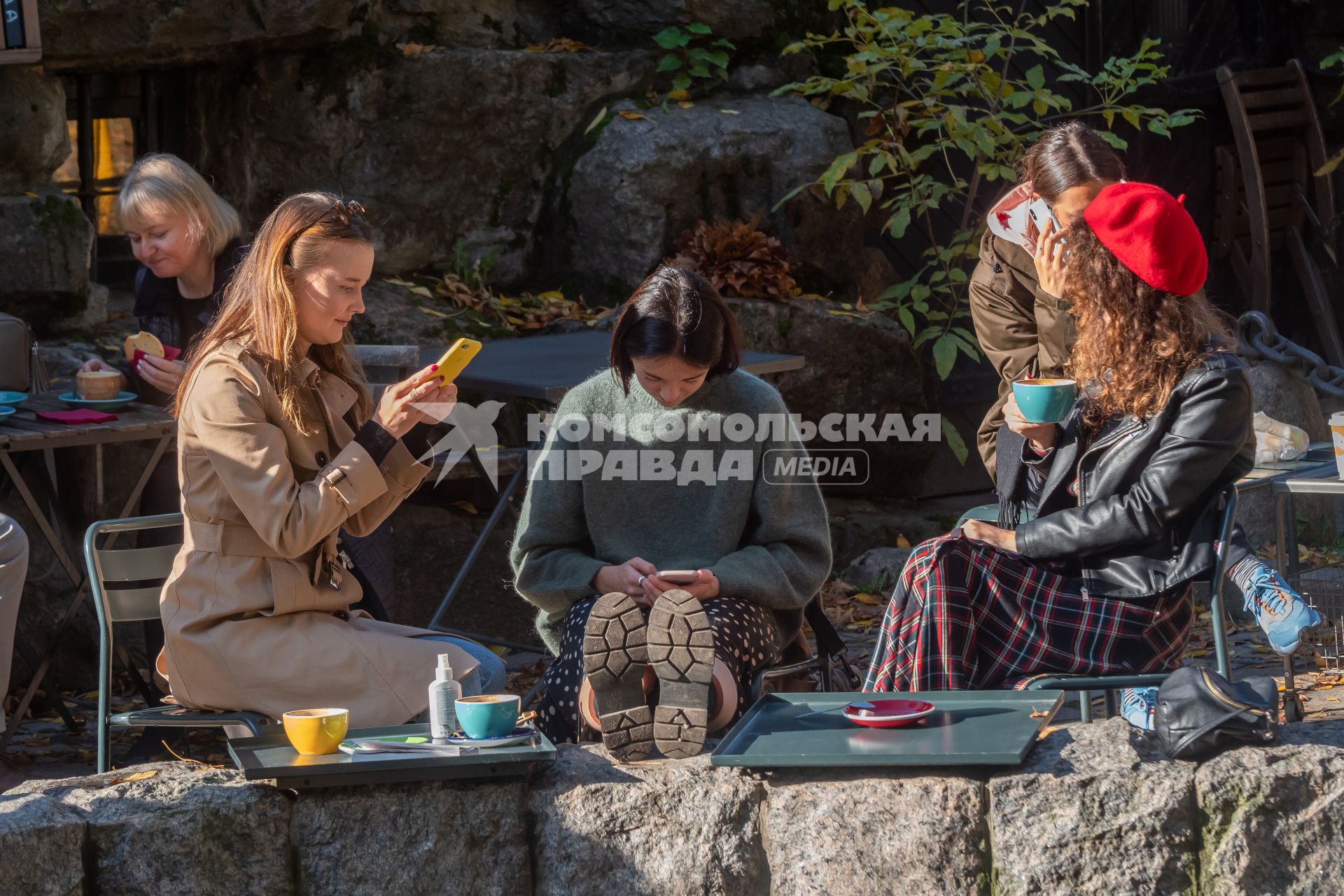 Санкт-Петербург. Девушки с мобильными телефонами сидят в кафе в Михайловском саду.