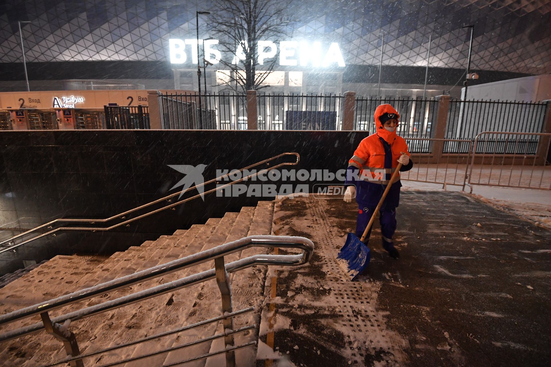 Москва. Дворник чистит снег на одной из улиц города во время снегопада.