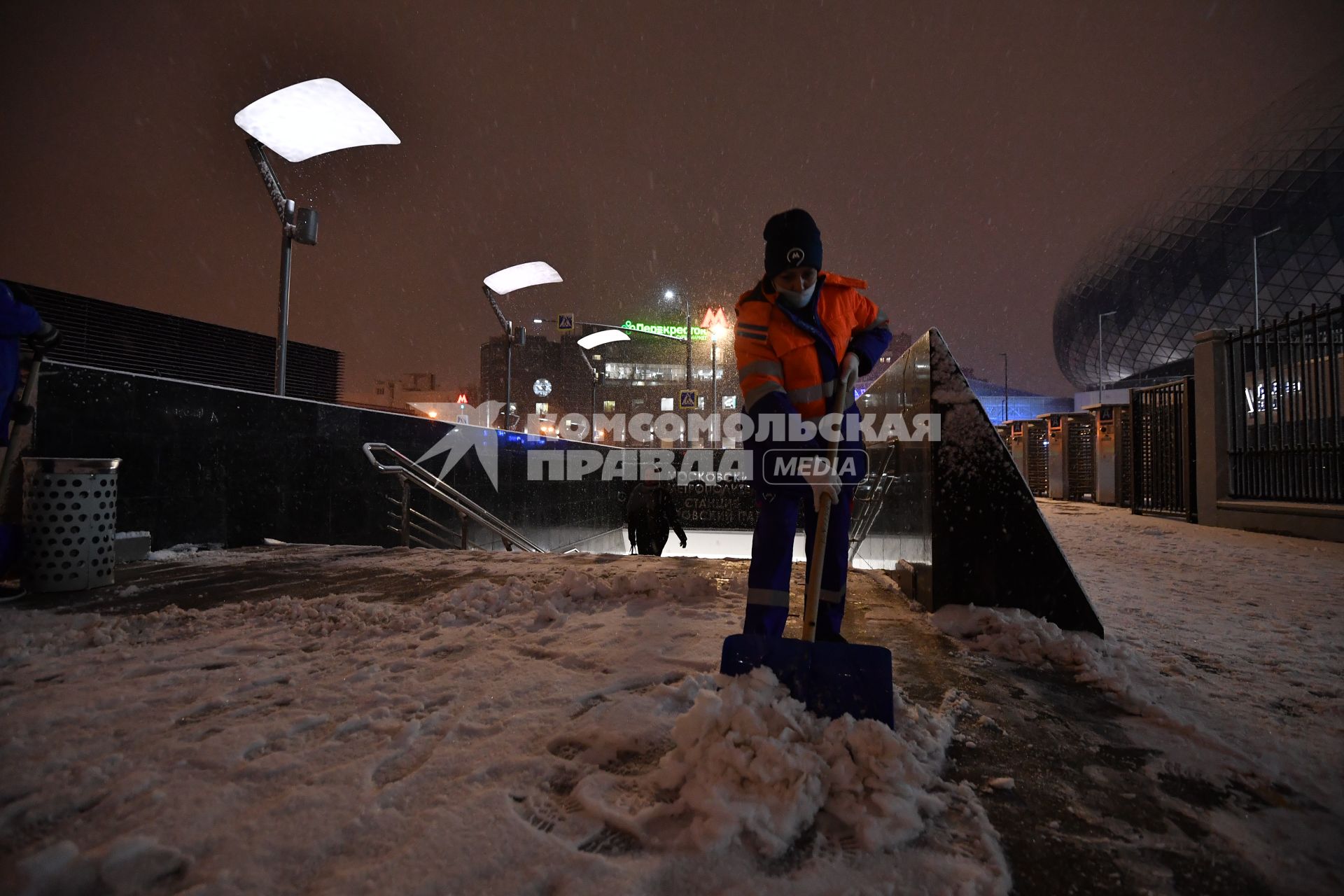 Москва. Дворник чистит снег на одной из улиц города во время снегопада.