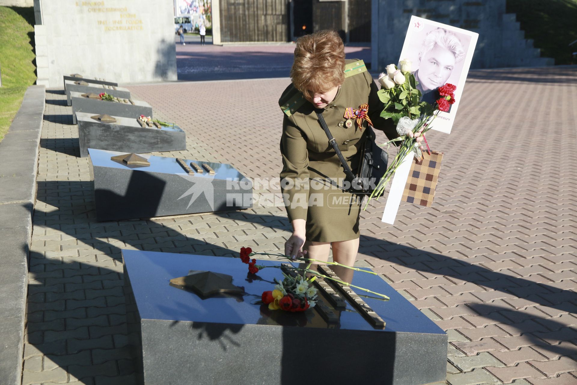 Барнаул. Женщина с цветами  у мемориального памятника  Защитникам Отечества в Великой Отечественной Войне.