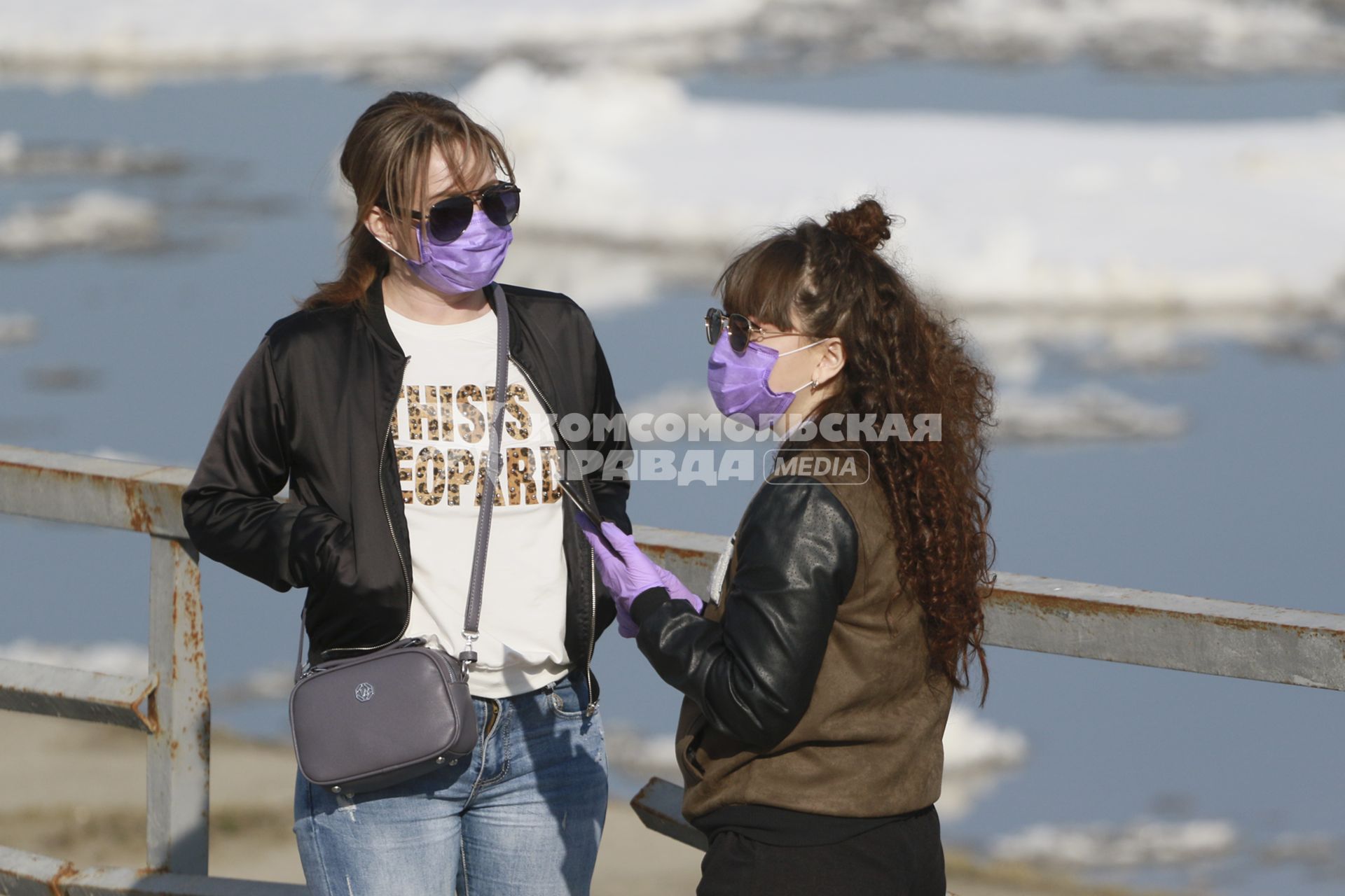 Барнаул. Девушки в защитных масках стоят на причале у реки Обь.