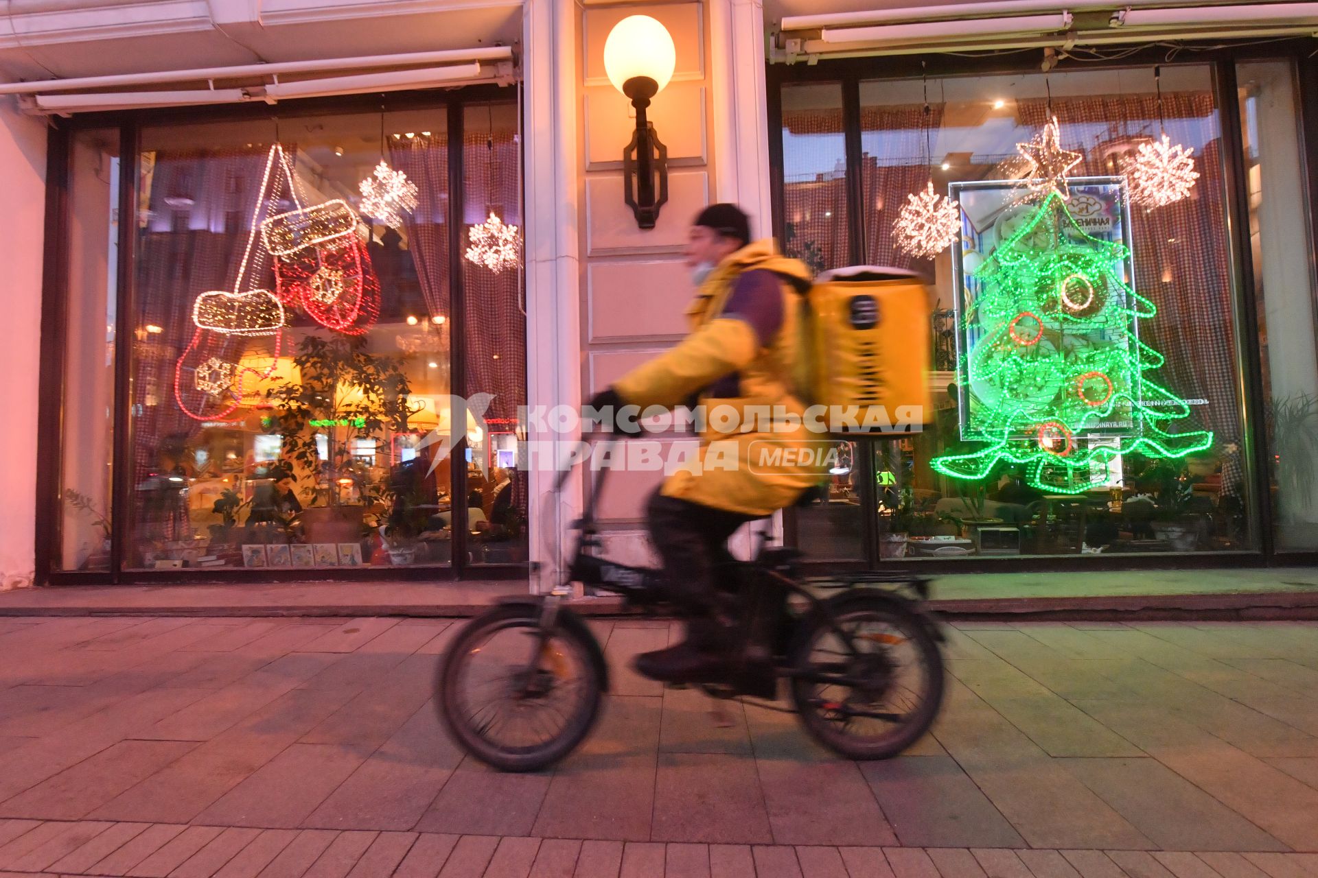 Москва.   Сотрудник сервиса доставки еды на улице города.