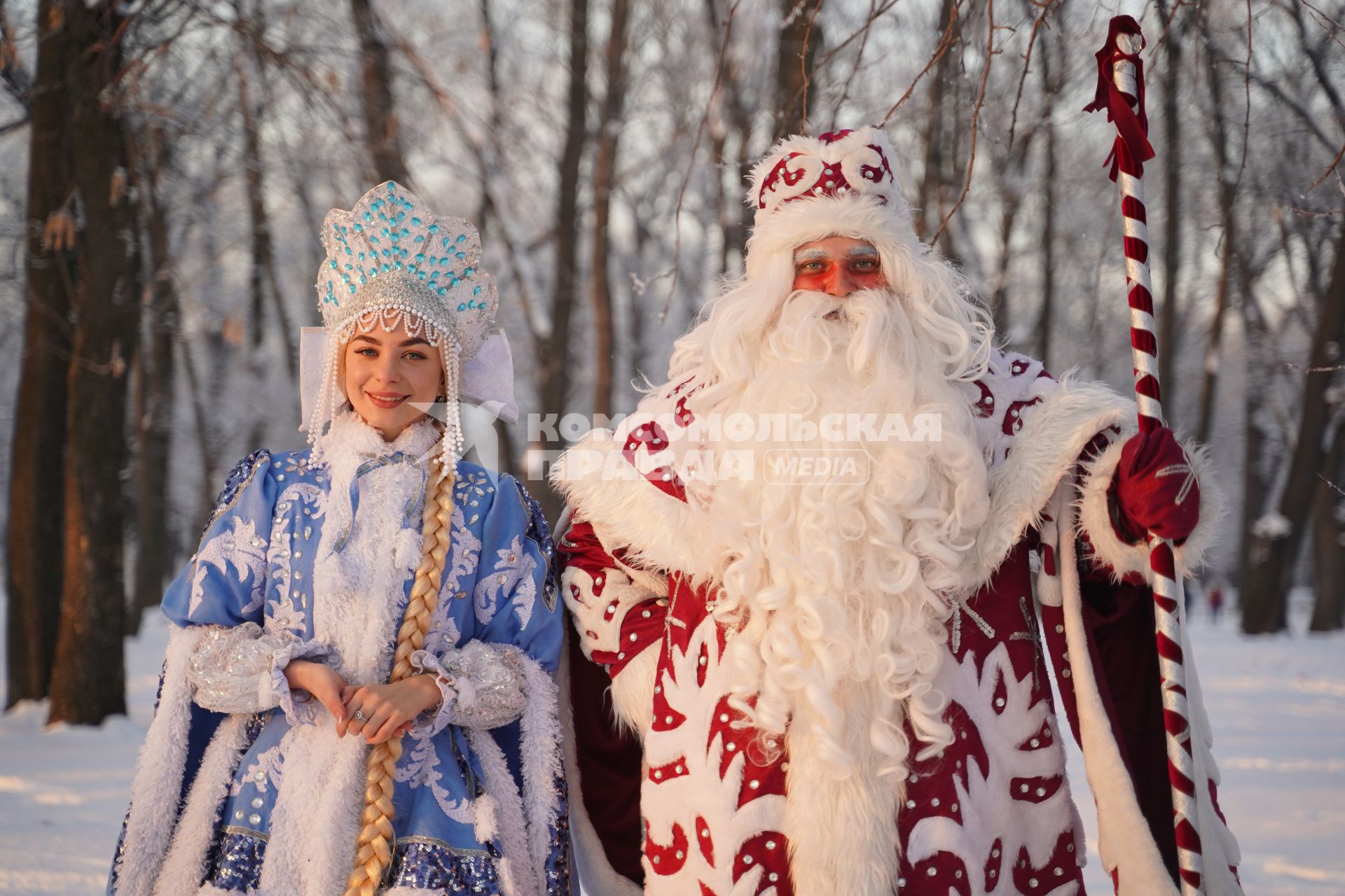 Самара. Люди в костюмах Деда Мороза и Снегурочки позируют в зимнем парке.