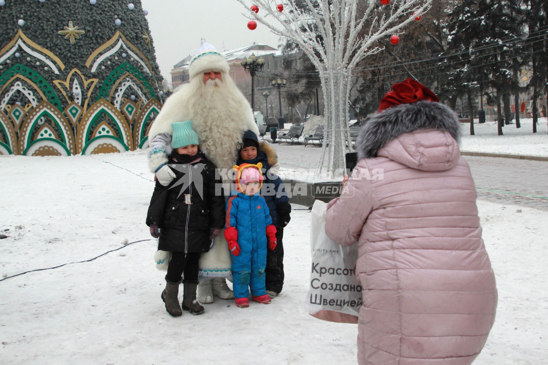 Иркутск. Байкальский Дед Мороз фотографируется с детьми на одной из улиц города.