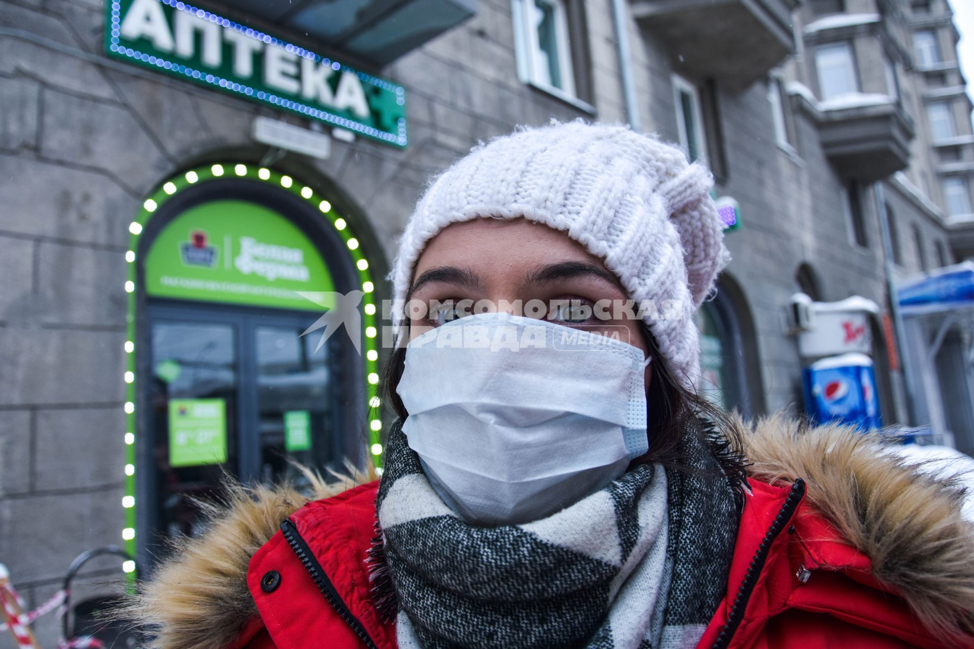 Новосибирск. Девушка в медицинской маске около аптеки.