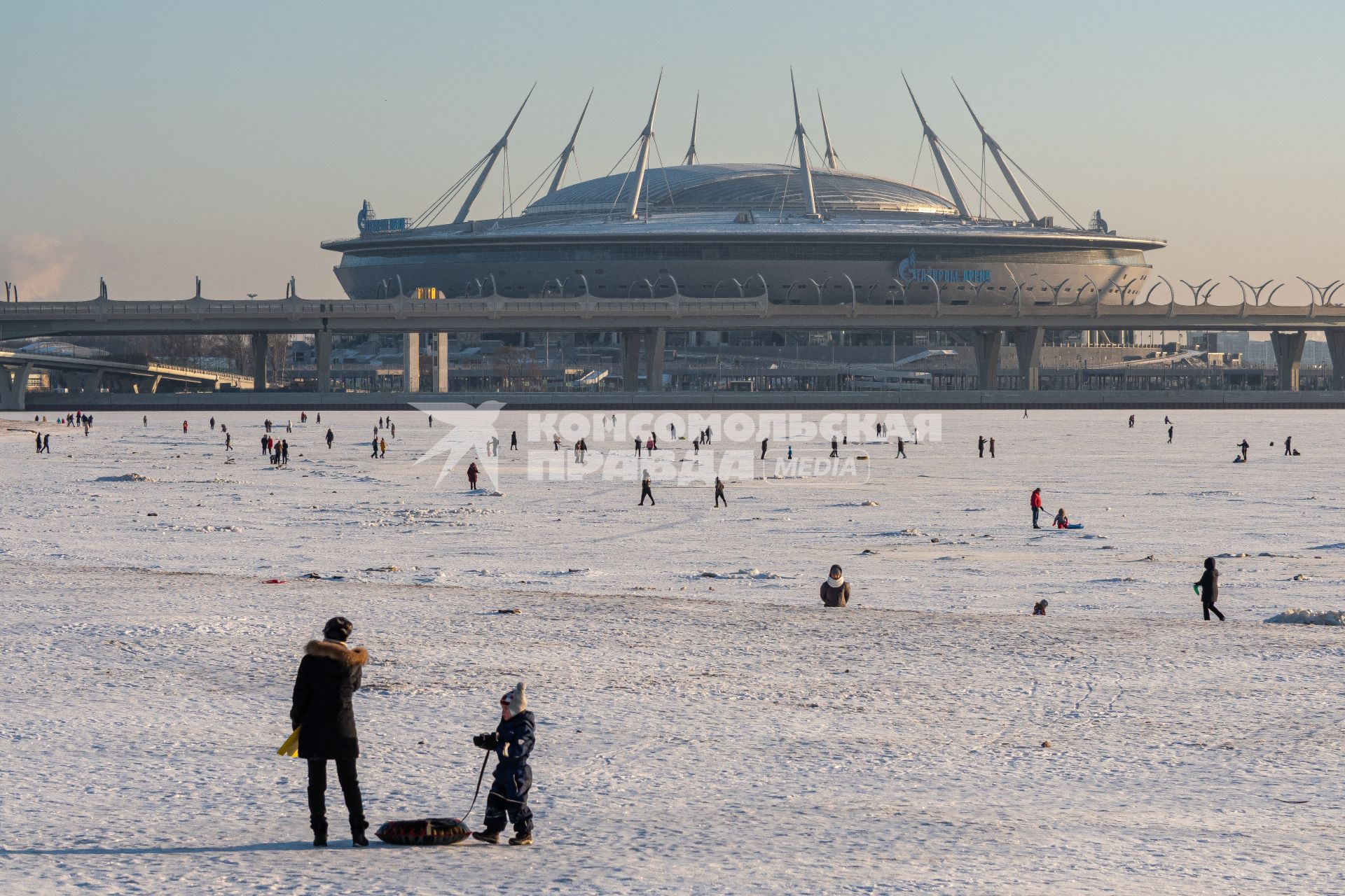 Санкт-Петербург. Горожане катаются на импровизированном катке Финского залива на фоне стадиона `Газпром-Арена`.