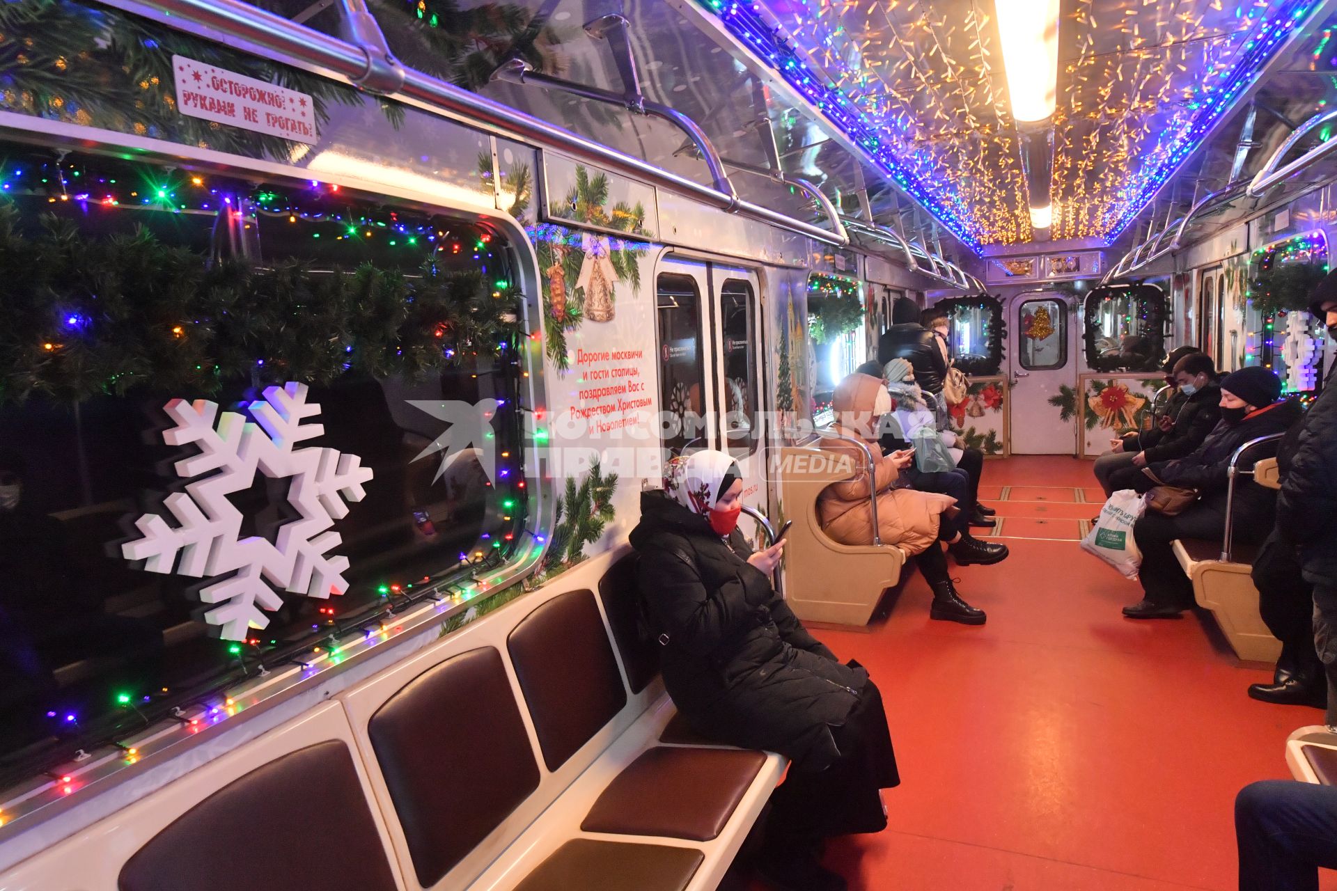 Москва.    Пассажиры в вагоне новогоднего поезда Московского метрополитена.