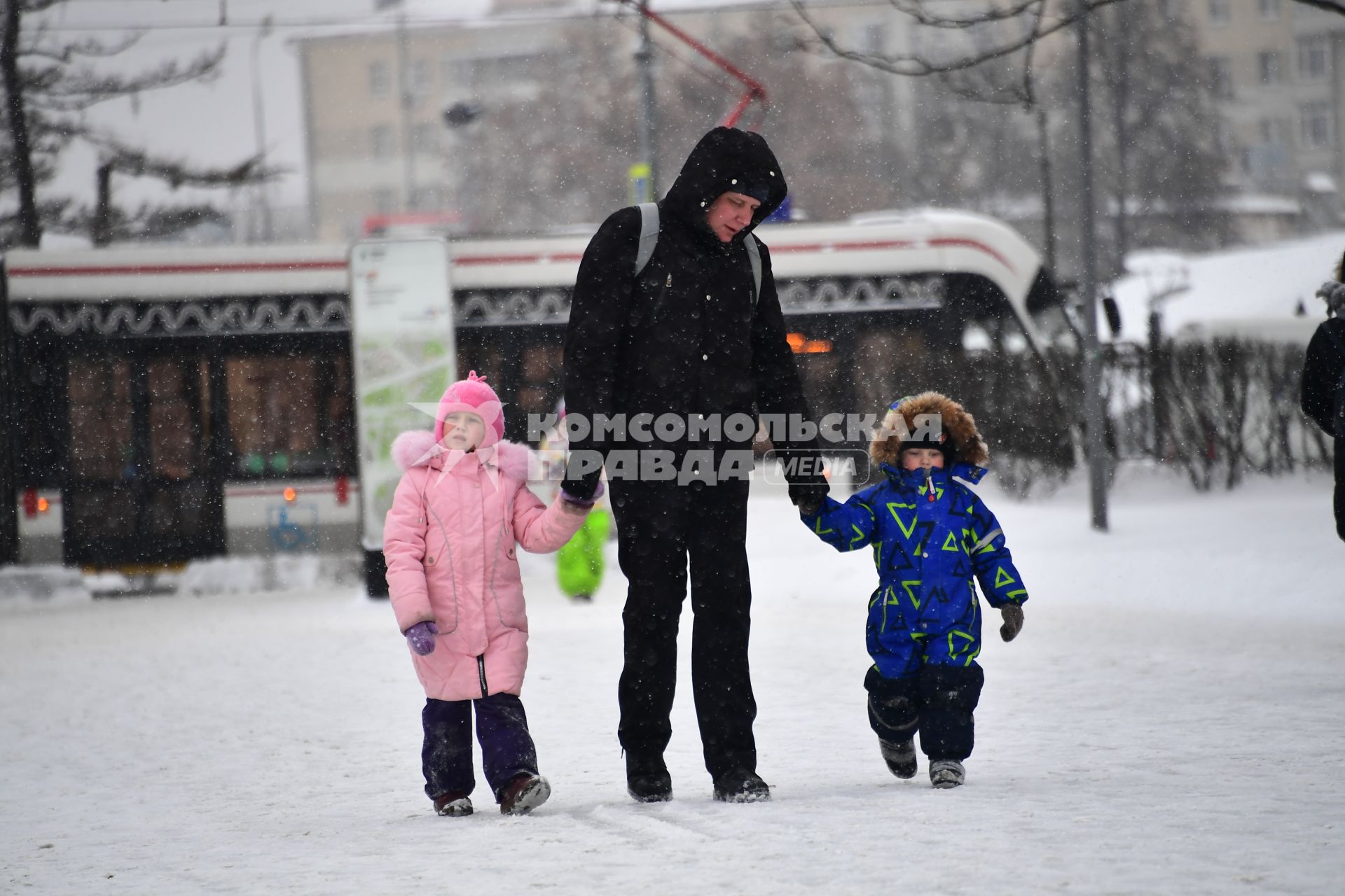 Москва.  Мужчина с детьми на одной из улиц города.