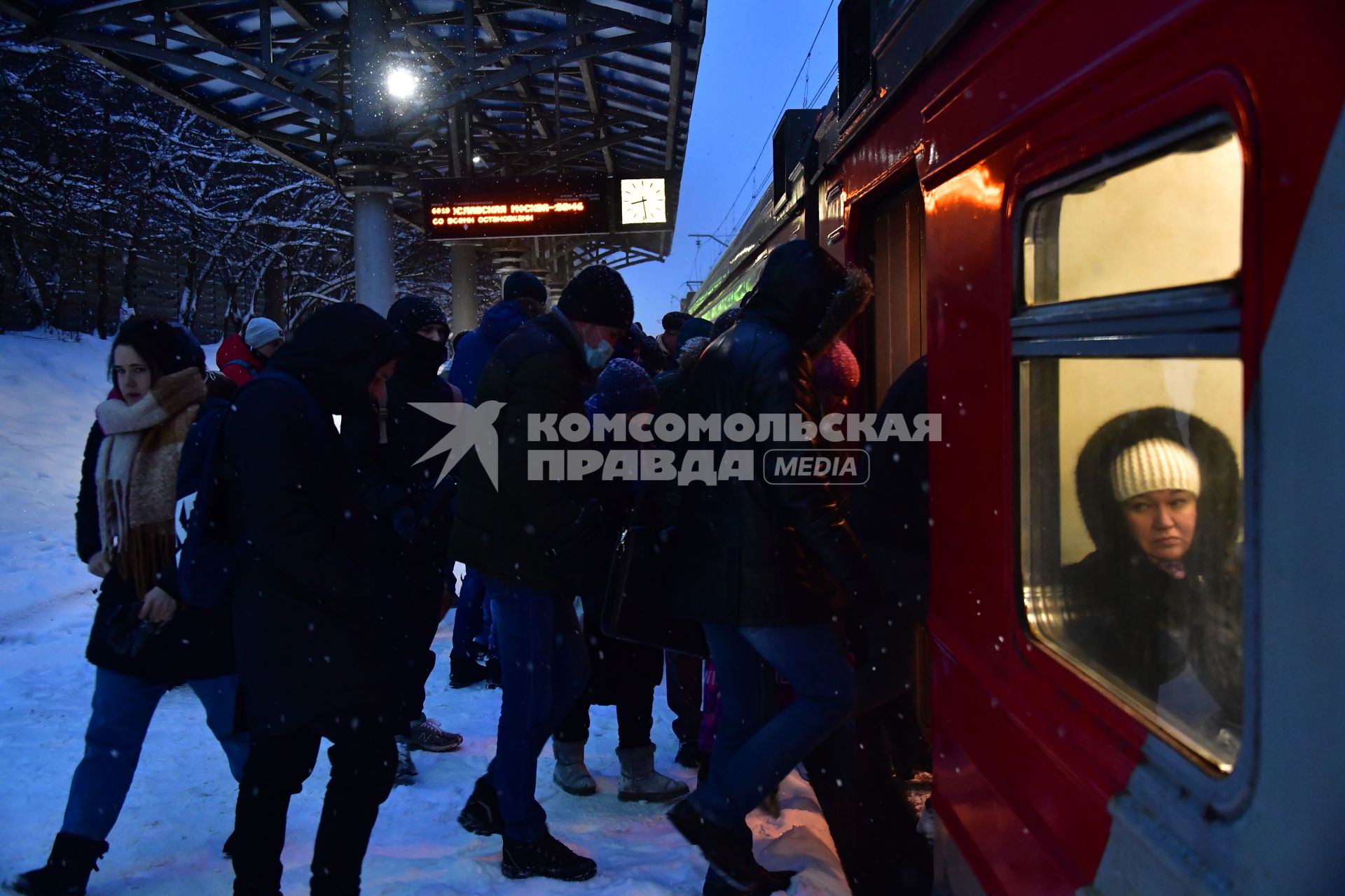 Москва.  Пассажиры на платформе пригородных поездов.