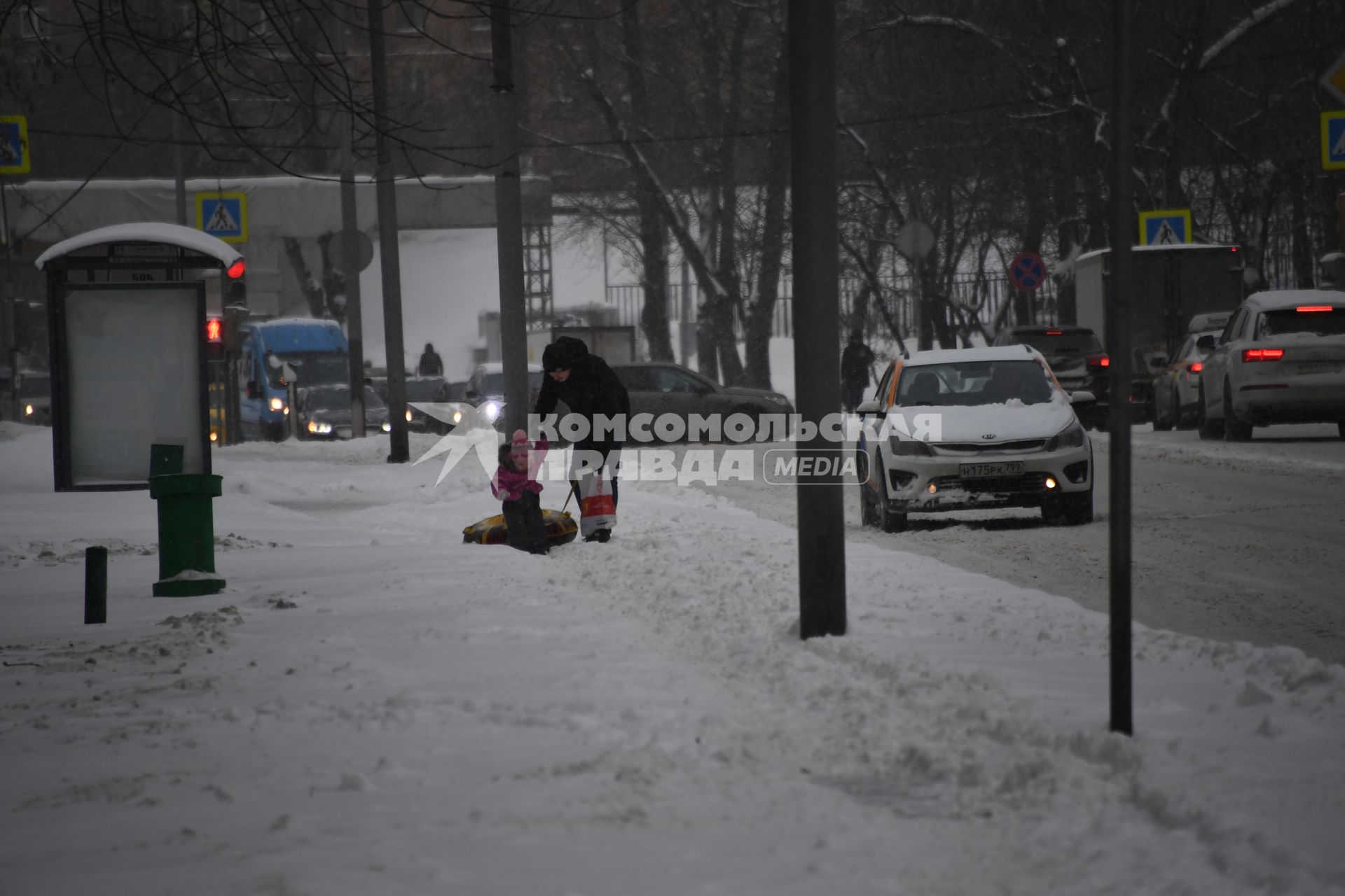 Москва. Мужчина с ребенком идут по заснеженному тротуару.