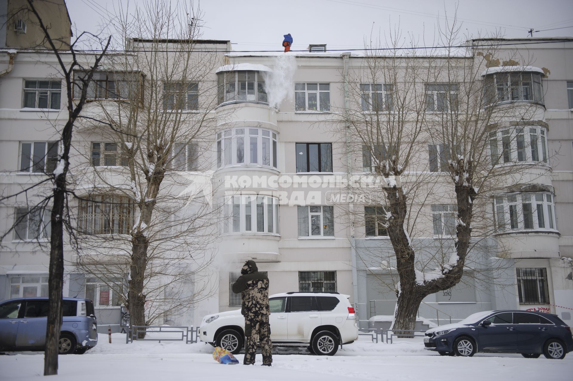 Екатеринбург. Рабочий чистит крышу жилого дома от снега, во время зимних морозов