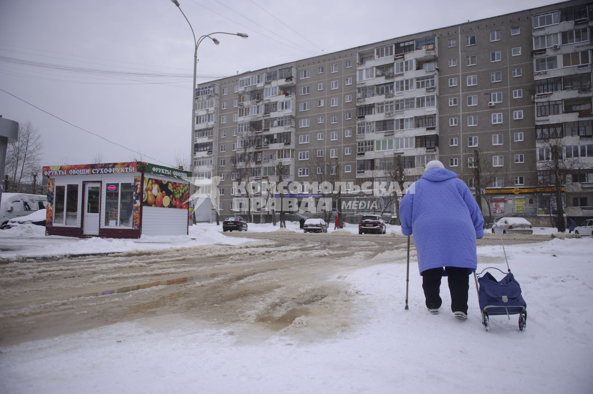 Екатеринбург. Бабушка обходит дорогу затопленную водой, после прорыва водопровода, во время зимних морозов