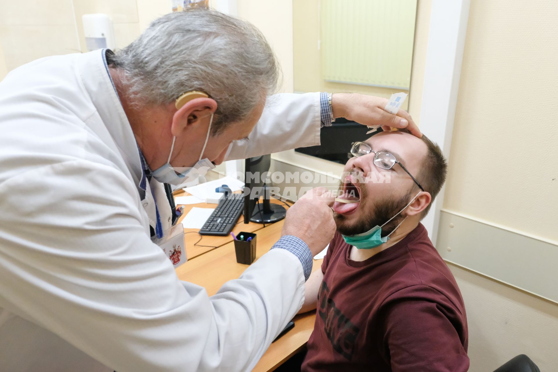 Санкт-Петербург. Врач осматривает мужчину перед вакцинацией от коронавирусной инфекции в поликлинике.