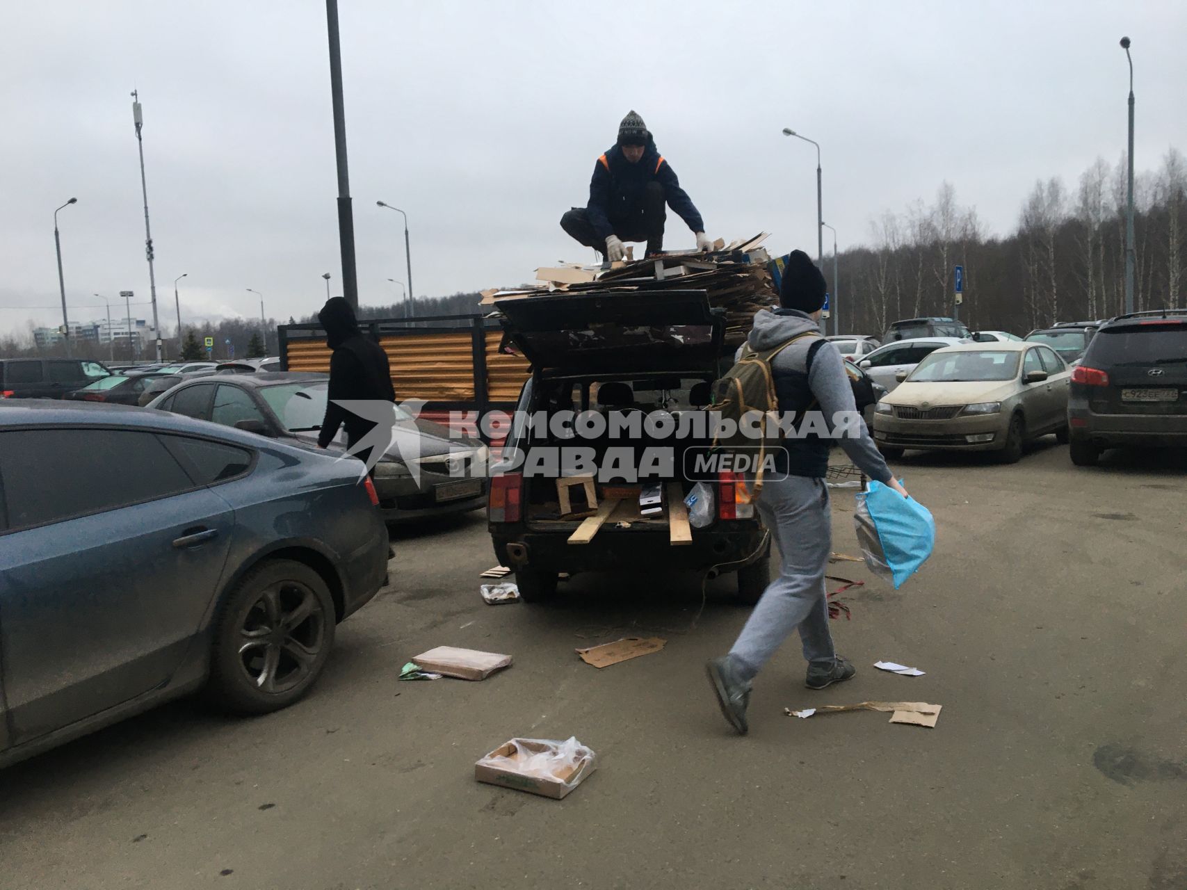 Москва. Дворники собирают картон и грузят на машину.