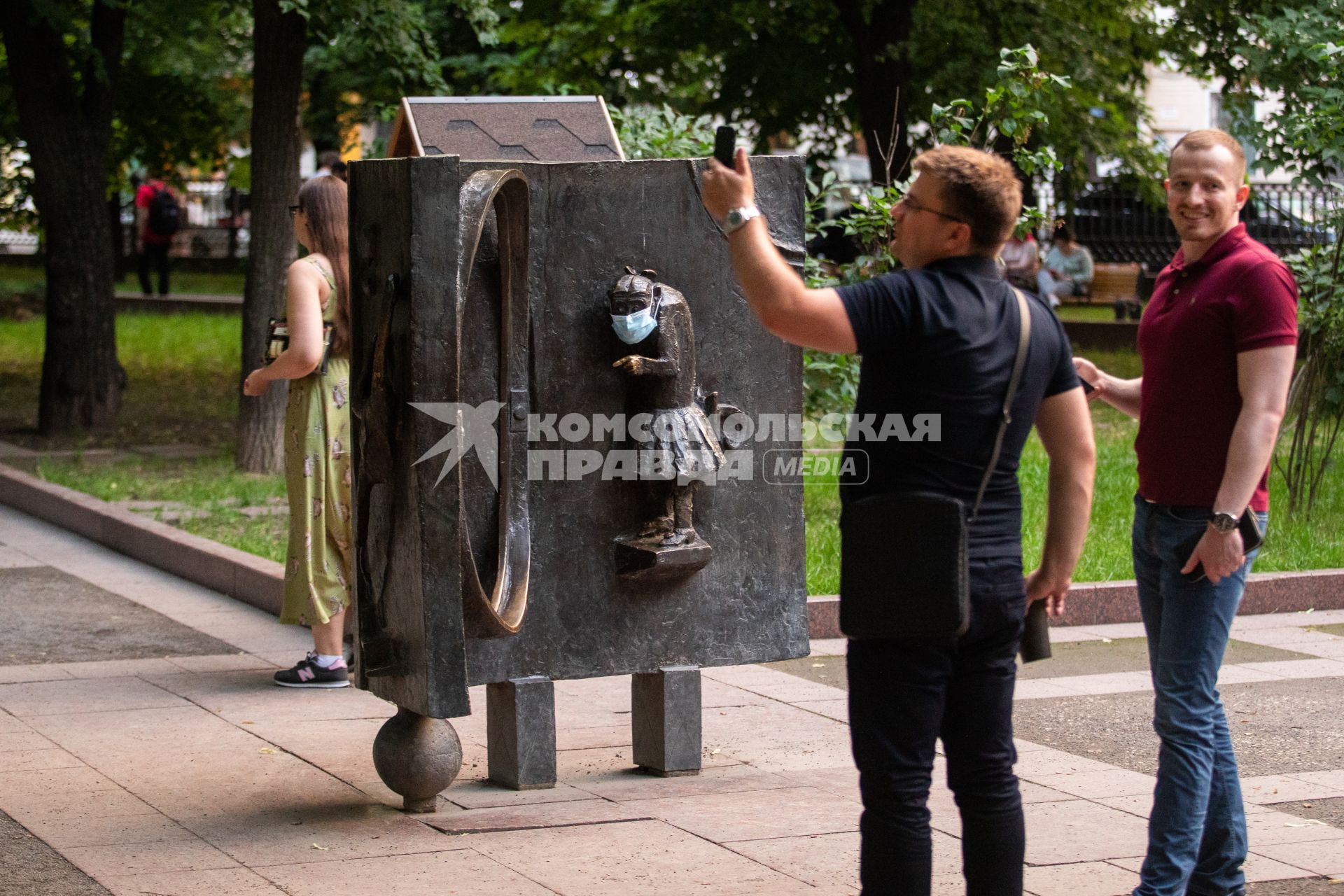 Москва.  Мужчина фотографируется у скульптур на Патриарших прудах после отмены режима самоизоляции.