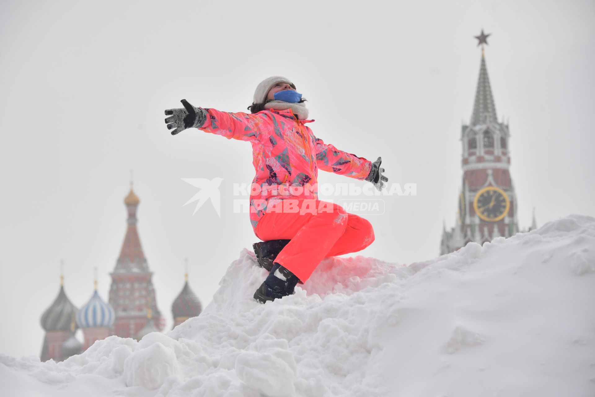 Москва. Девочка играет на снежной горке на Красной площади