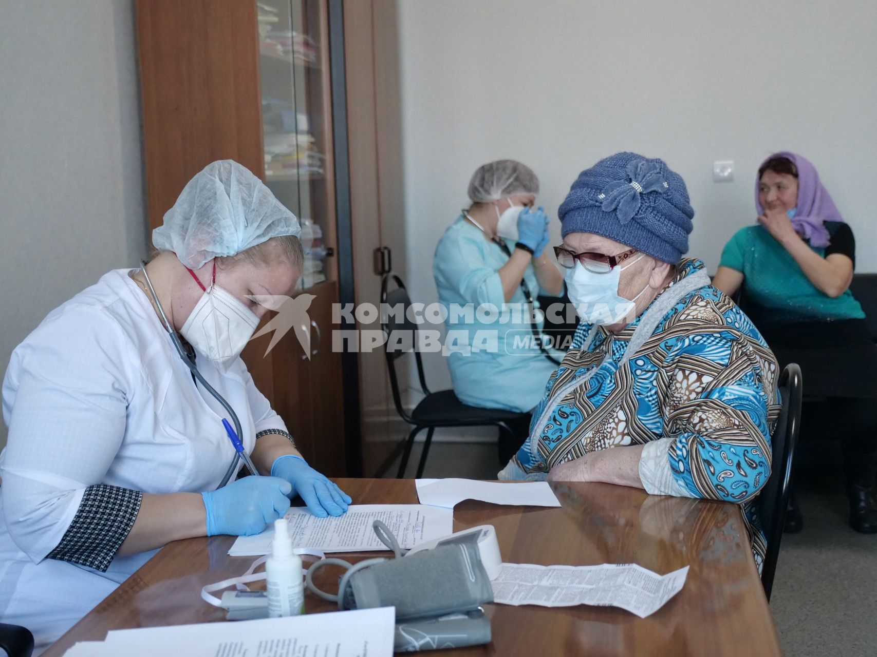 Самарская область, с. Рождествено.   Врач осматривает женщину перед вакцинацией от коронавирусной инфекции в поликлинике.