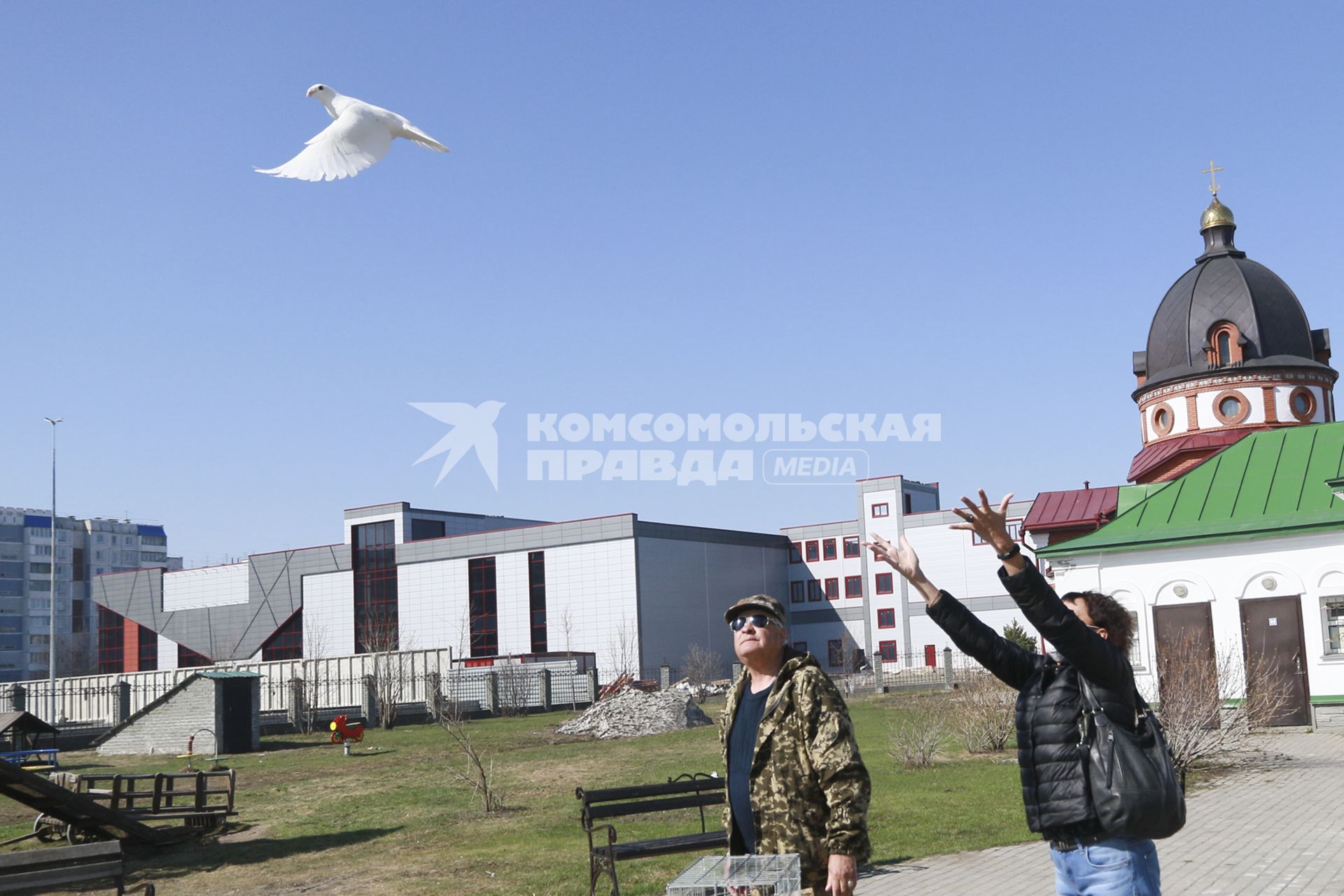 Барнаул. Женщина выпускает в небо голубя в праздник Благовещения Пресвятой Богородицы.