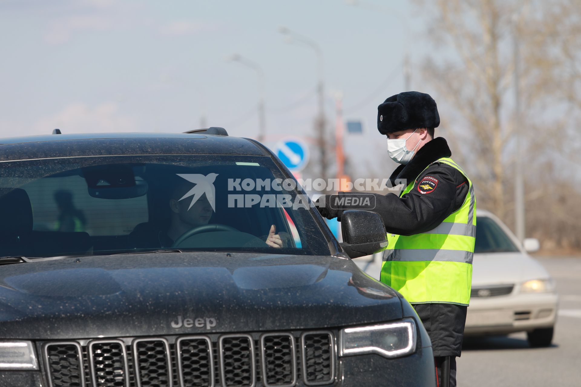 Красноярск. Сотрудник ДПС проверяет документы у водителя на въезде в город в связи с введением дополнительных ограничений из-за распространения коронавируса COVID-19.