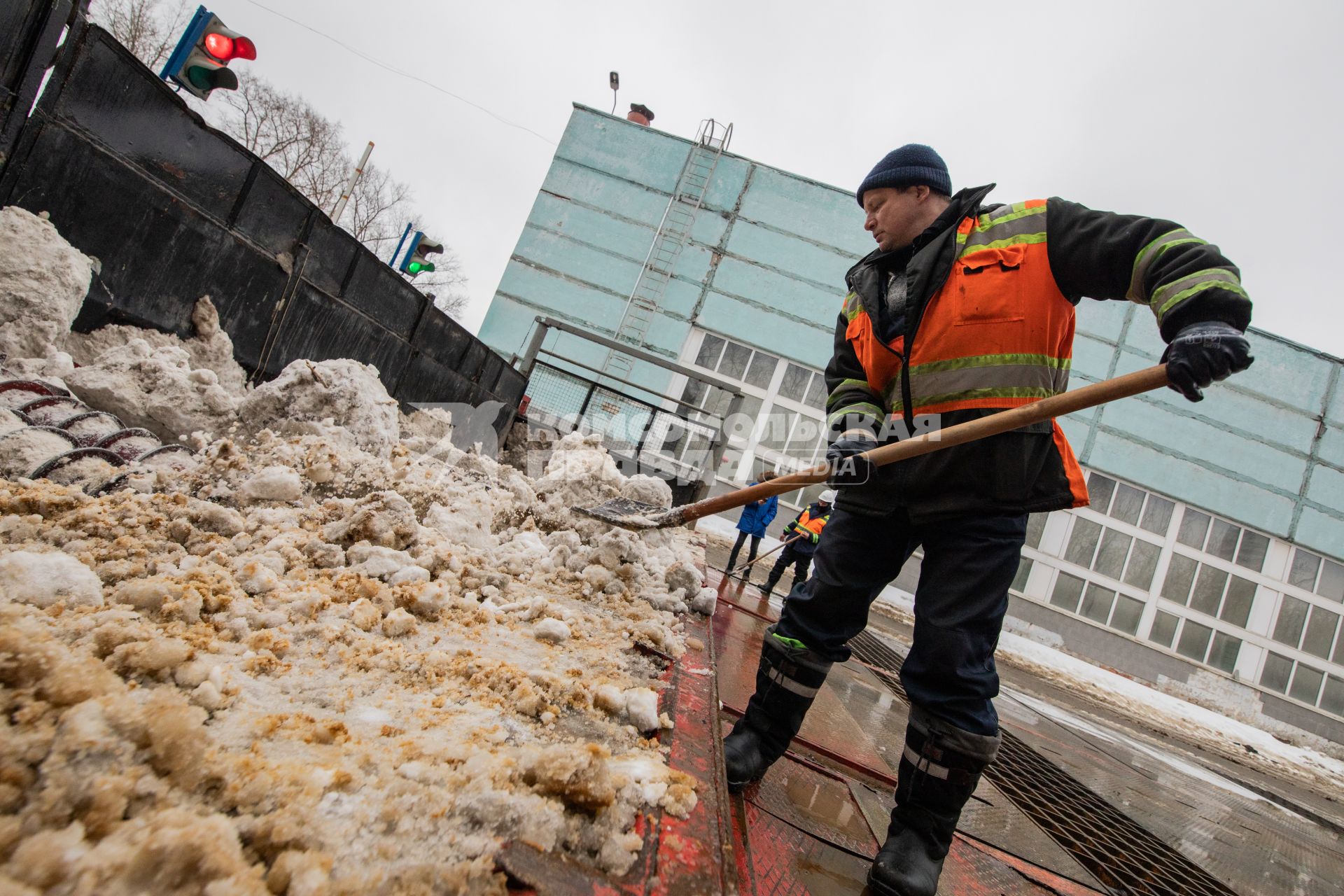 Москва. Сотрудник снегоплавильного пункта ГУП`Мосводосток`во время разгрузки грузовых автомобилей со снегом.