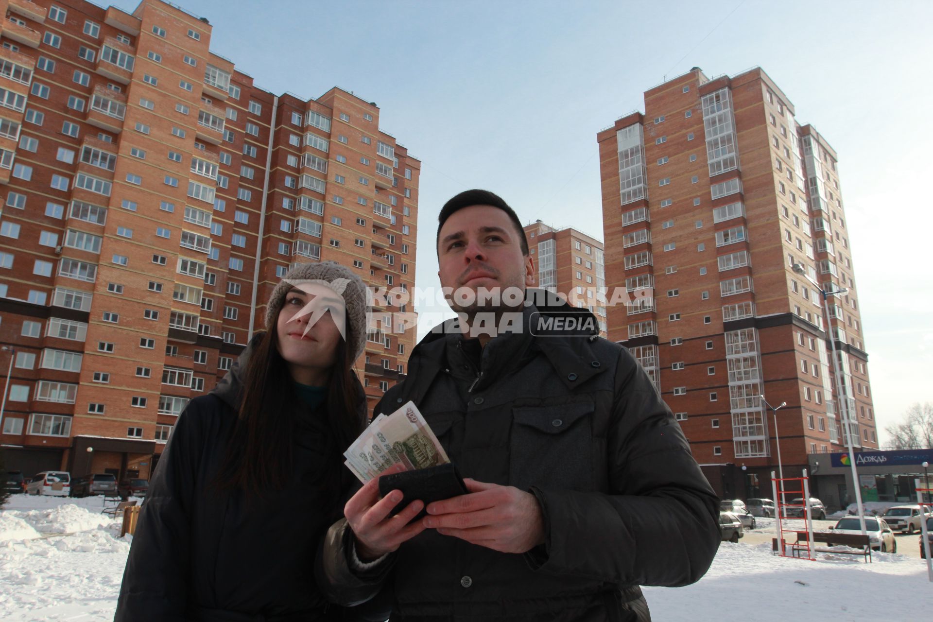 Иркутск. Молодой человек с девушкой осматривают новостройки в новом микрорайоне.