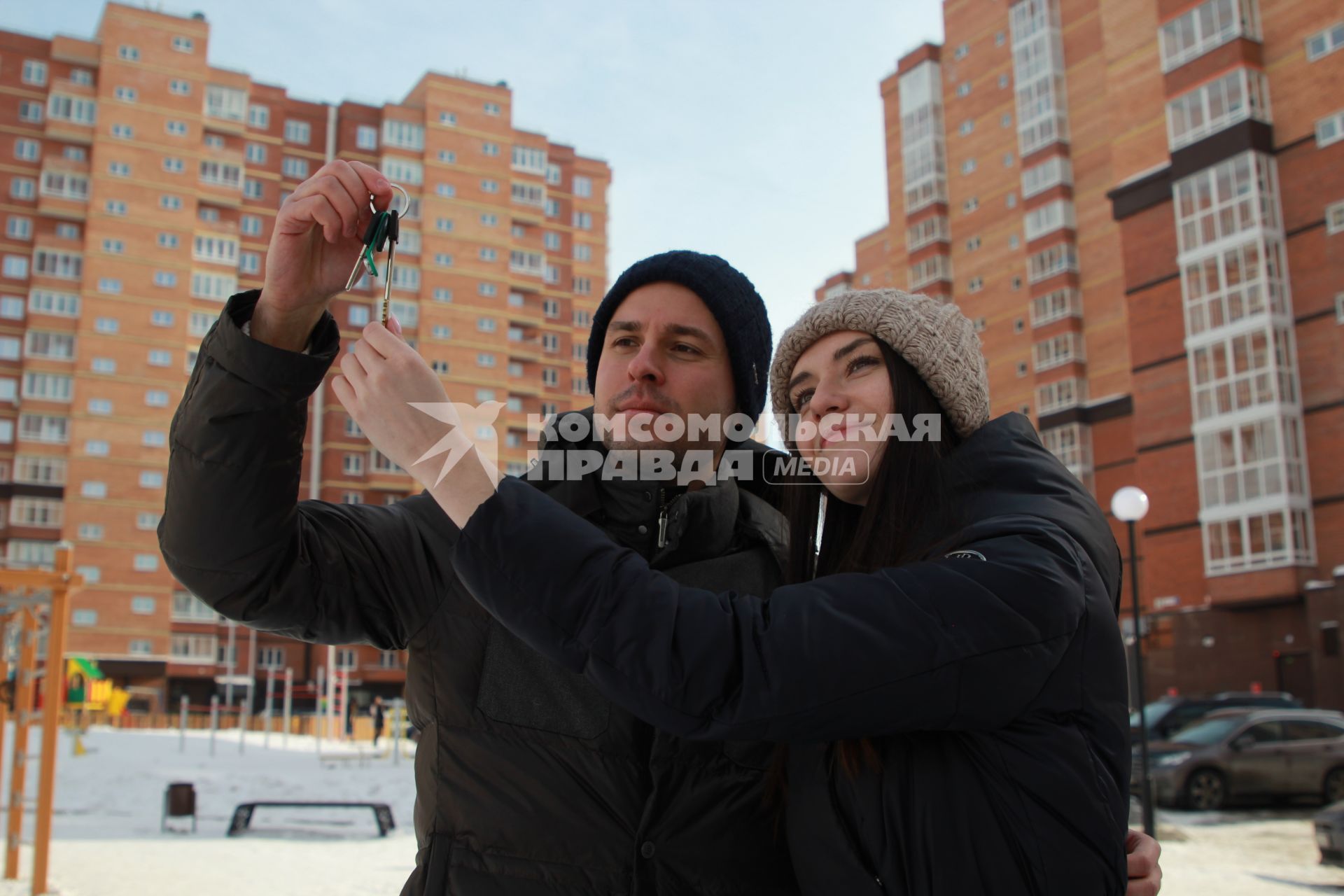 Иркутск. Молодой человек держит в руке ключи от квартиры в новостройке.