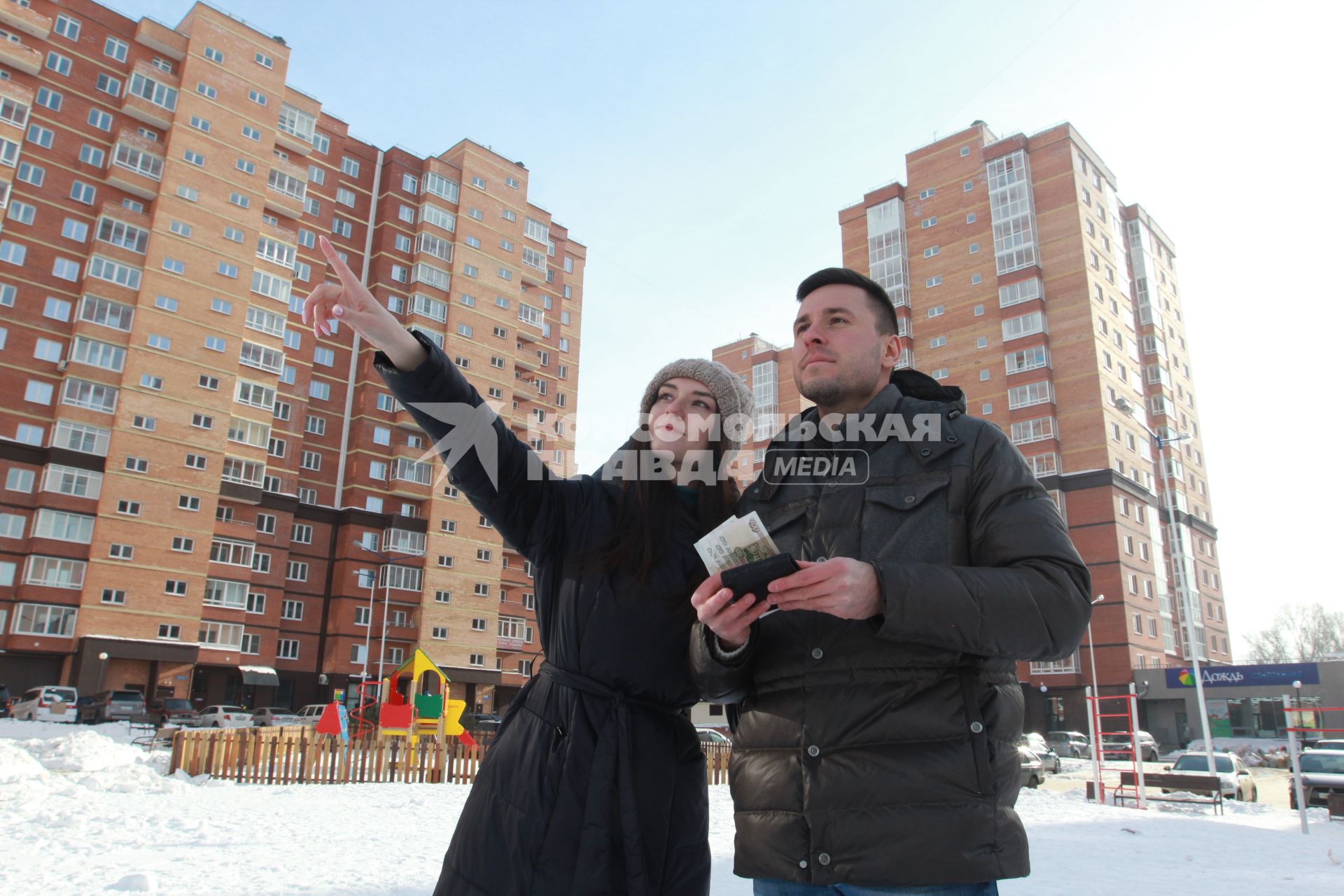 Иркутск. Молодой человек с девушкой осматривают новостройки в новом микрорайоне.