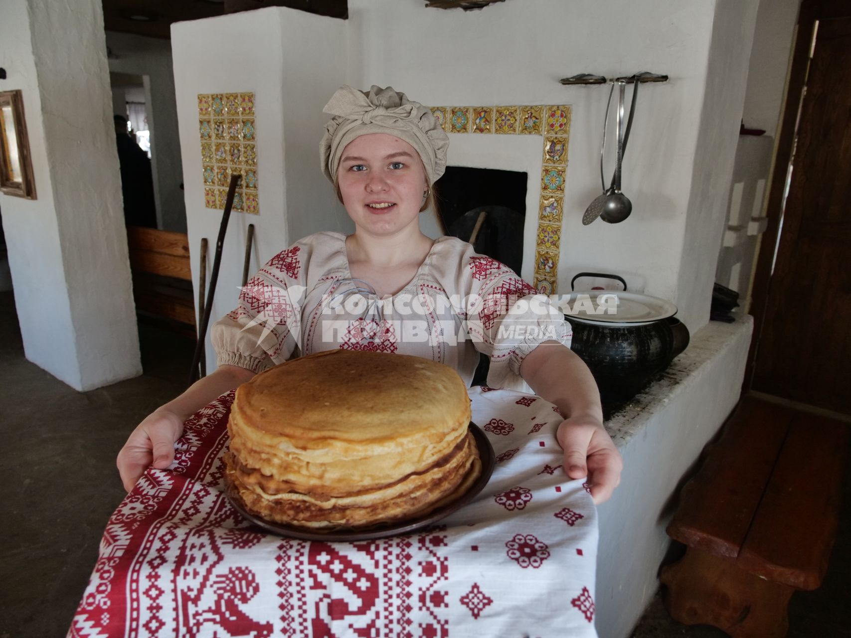 Ульяновск. Девушка в русском национальном костюме держит тарелку с блинами.