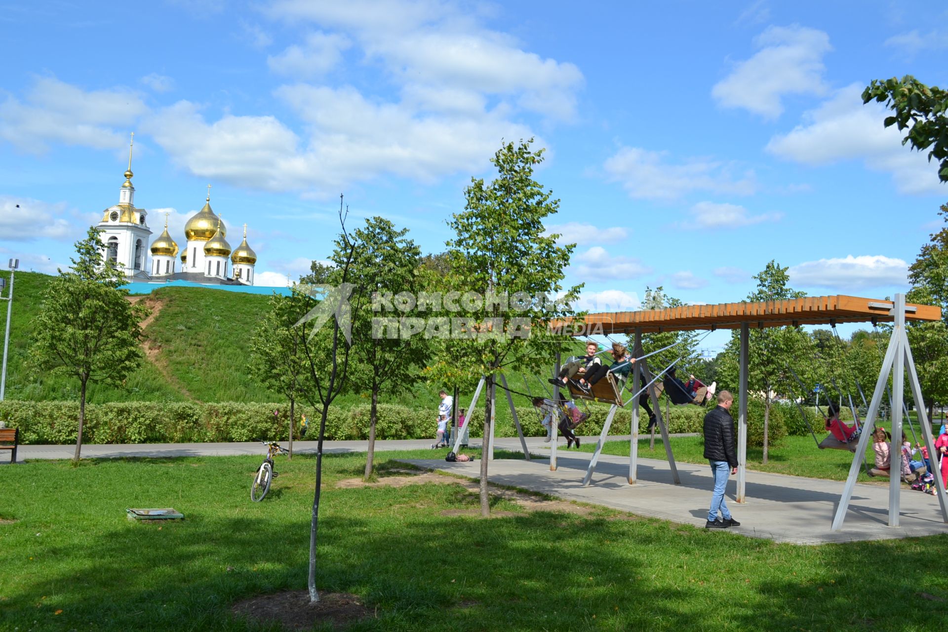 Московская область, Дмитров.   Люди качаются на качелях.