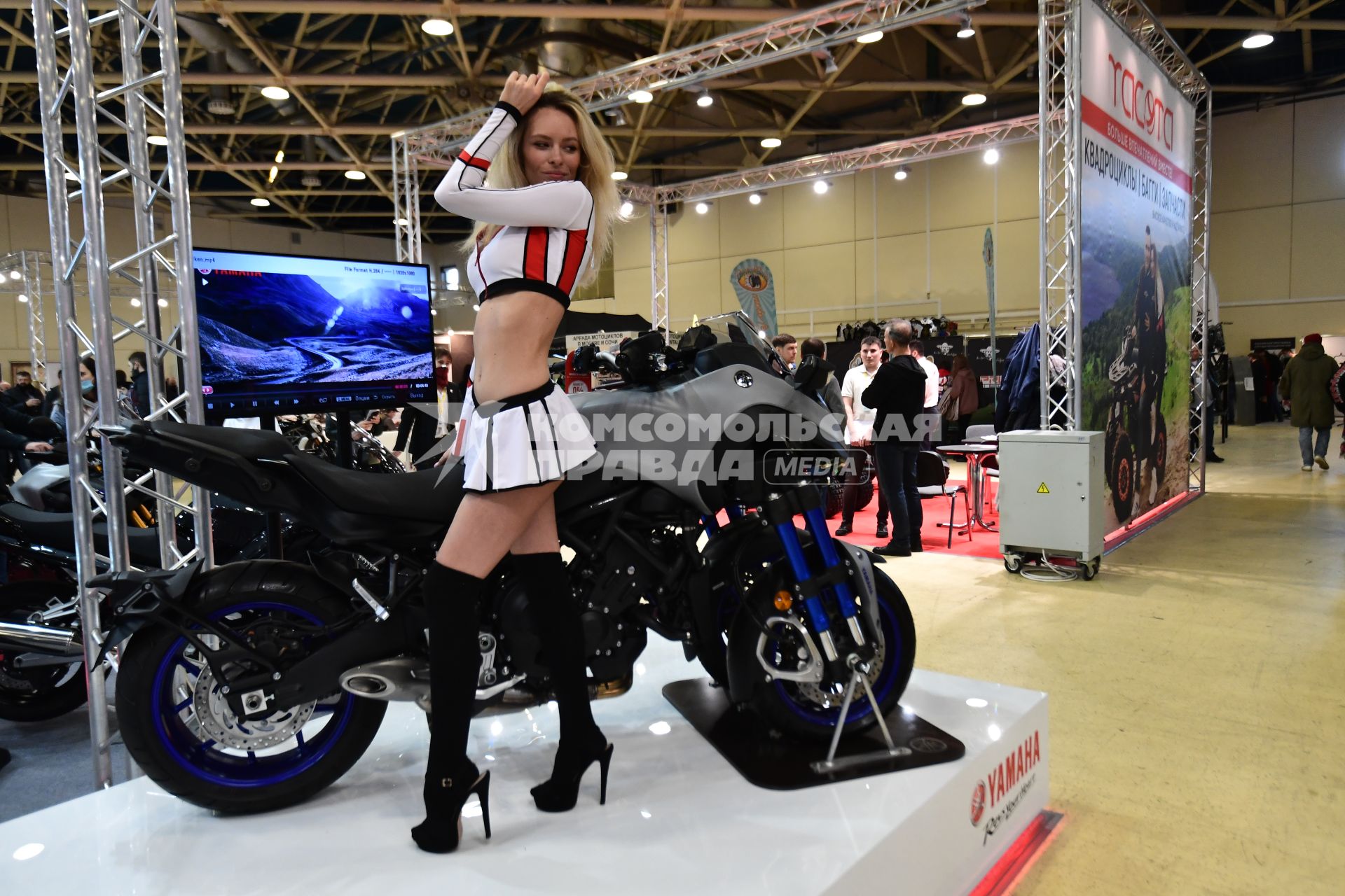 Москва.  Модель рядом с мотоциклом  Yamaha на международной выставке `Мотовесна-2021` в московском Экспоцентре на Красной Пресне.