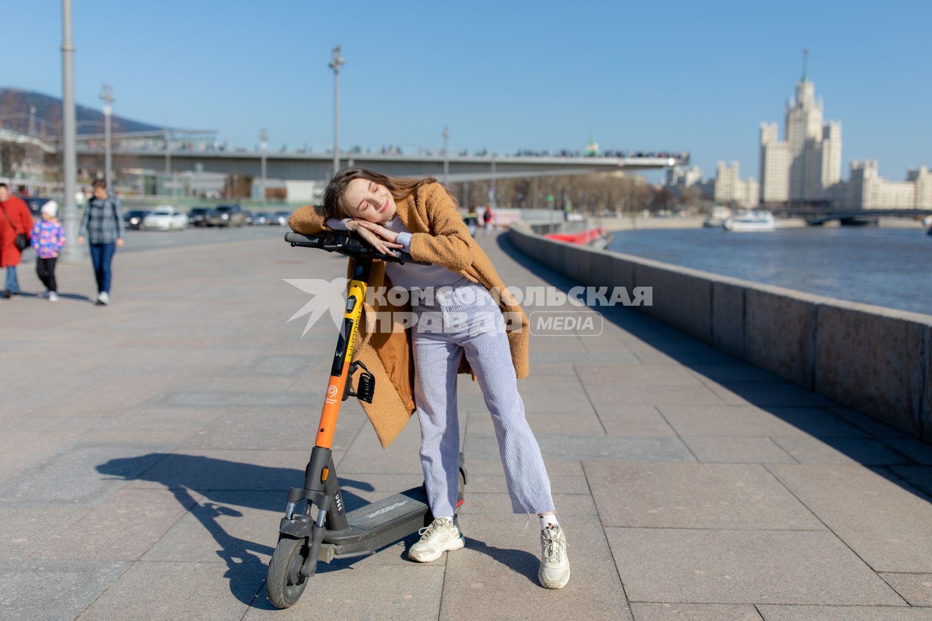 Москва.  Девушка с электросамокатом на Москворецкой набережной.