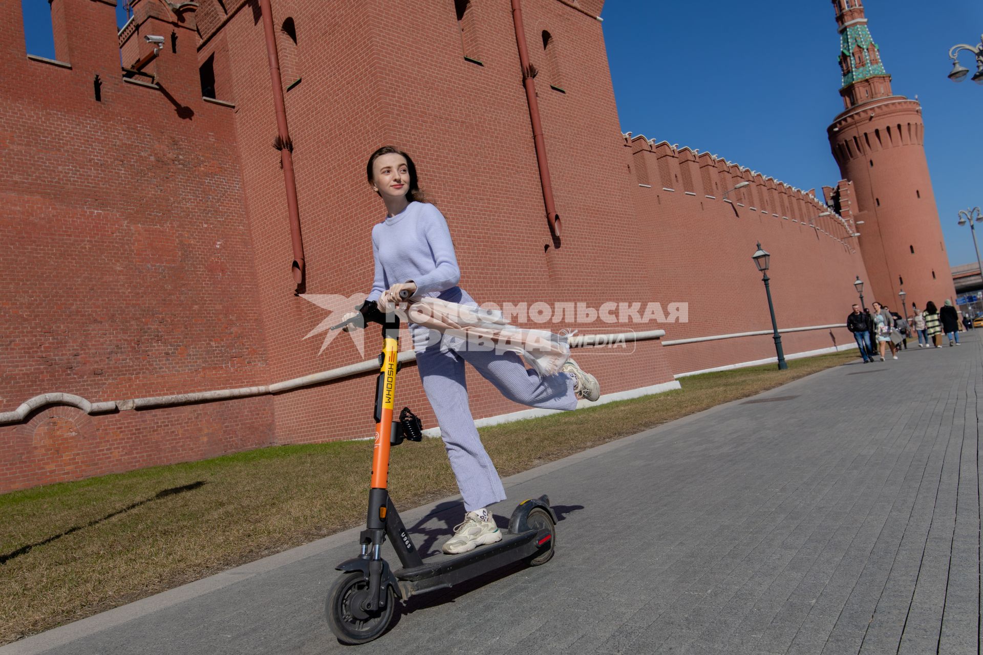 Москва. Девушка с электросамокатом на Кремлевской набережной.