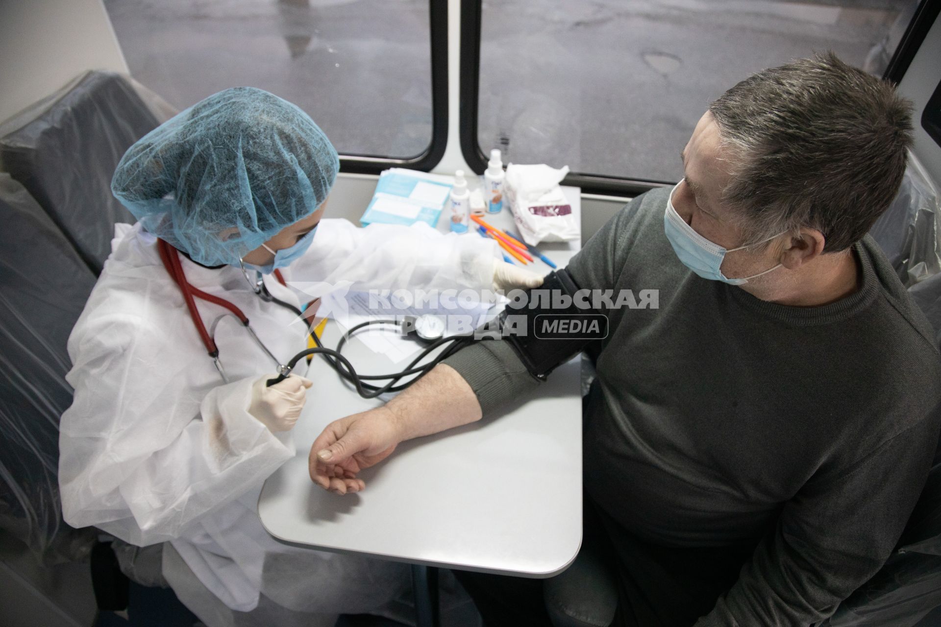 Пермь. Врач проводит осмотр мужчины перед вакцинацией от коронавирусной инфекции в мобильном  пункте вакцинации.