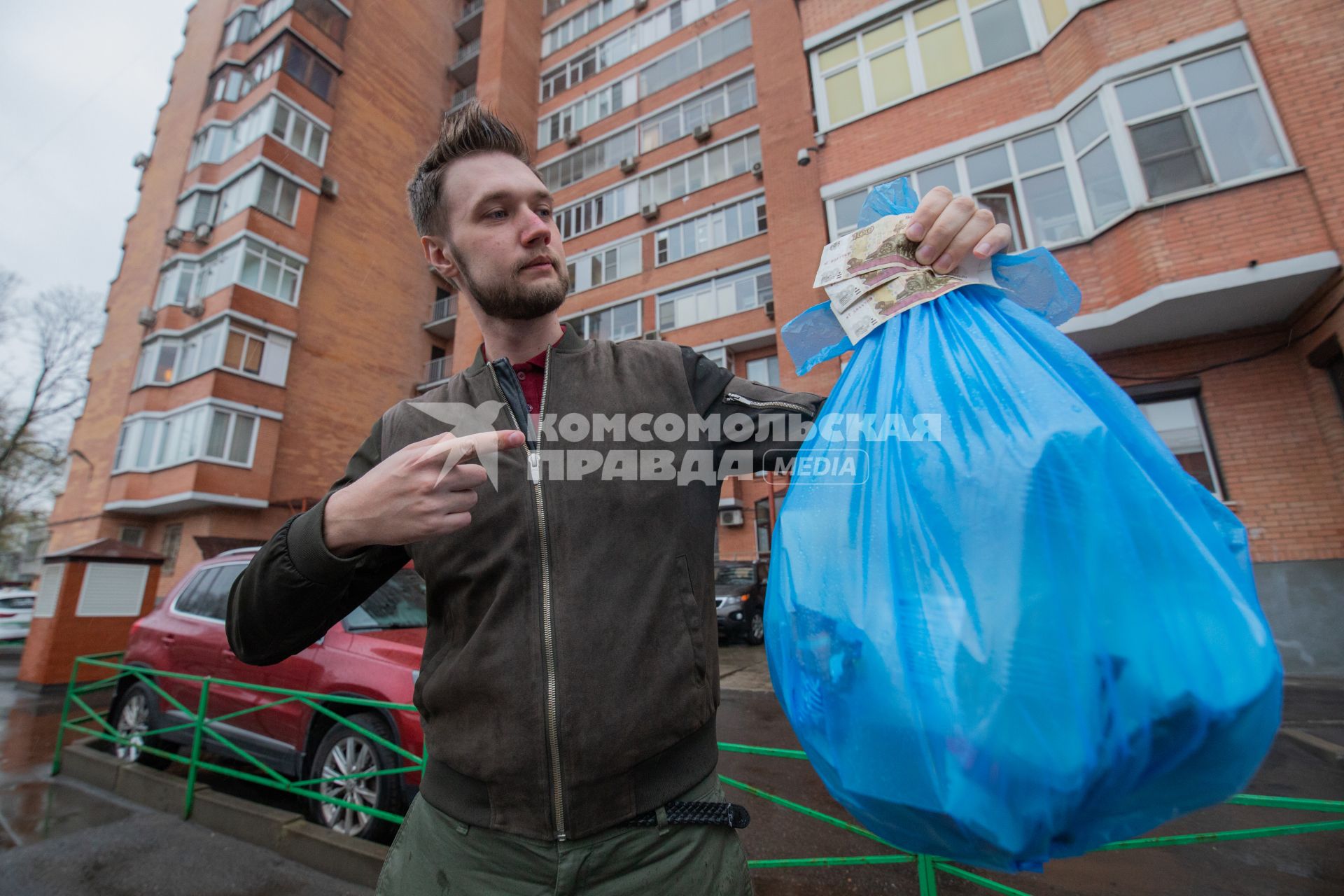 Москва. Корреспондент `Комсомольской правды` Андрей Абрамов держит в руке пакет с мусором и деньги.