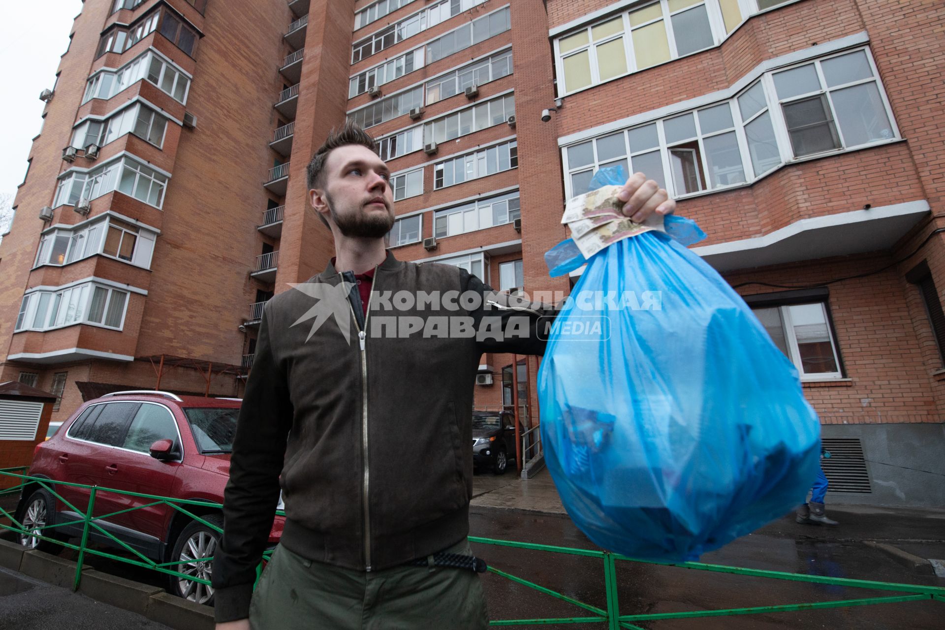 Москва. Корреспондент `Комсомольской правды` Андрей Абрамов держит в руке пакет с мусором и деньги.