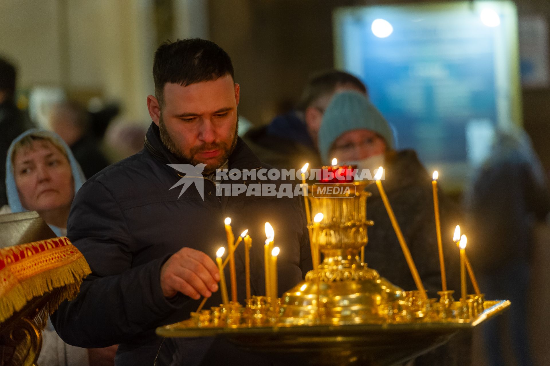 Санкт-Петербург. Мужчина ставит свечку в Казанском кафедральном соборе во время Пасхального богослужения.