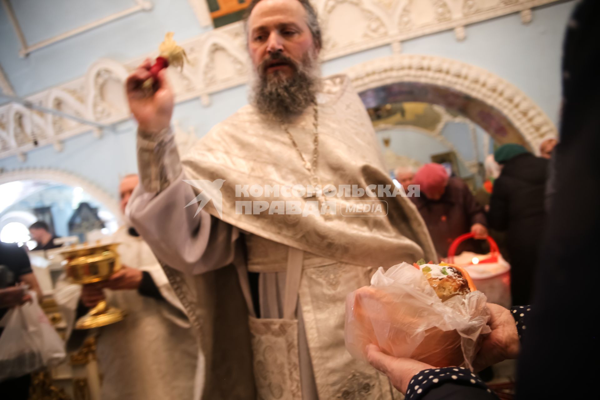 Красноярск. Прихожане и священнослужитель во время освящения пасхальных куличей и яиц в Покровском кафедральном соборе.