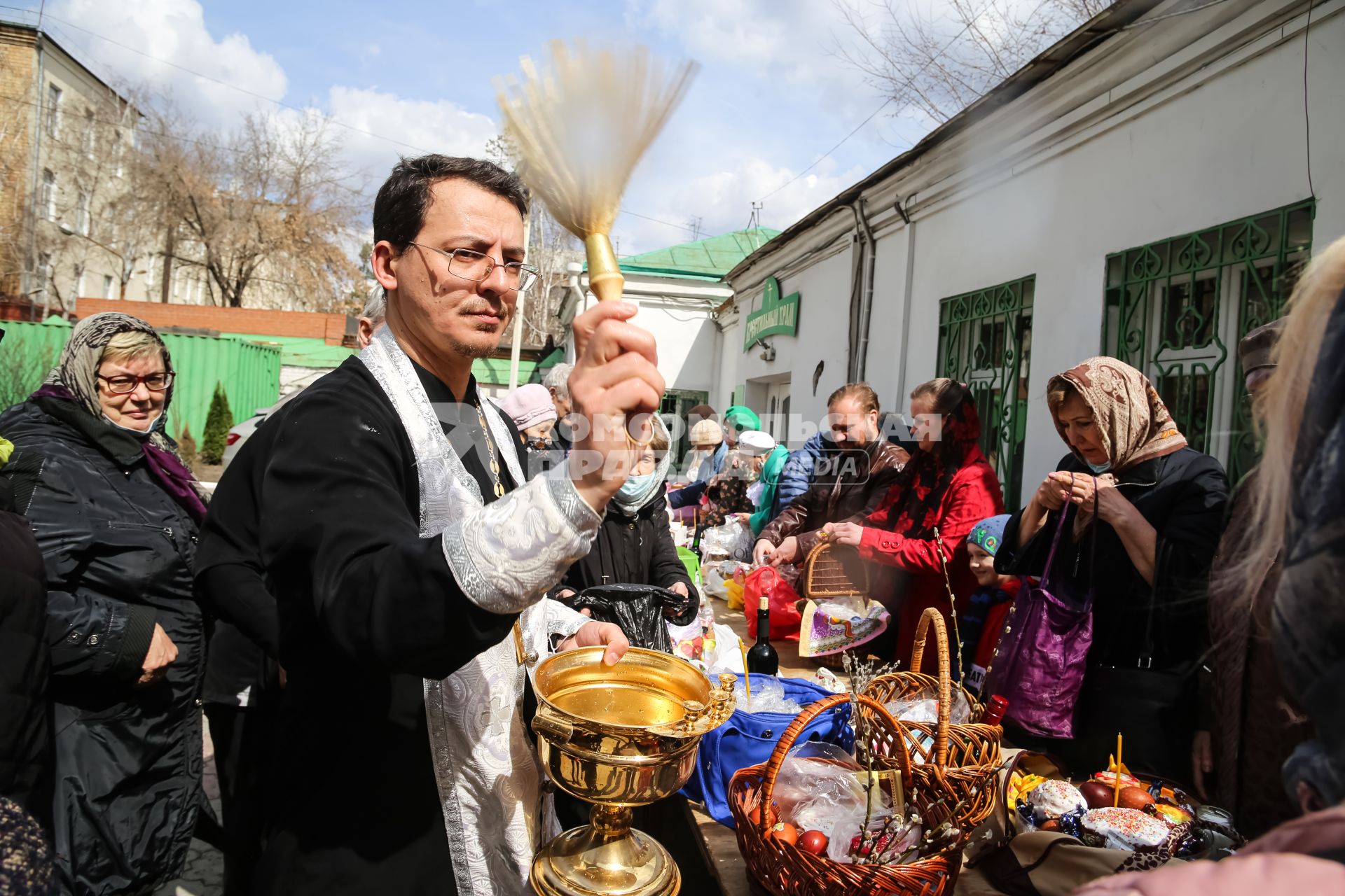 Красноярск. Прихожане и священнослужитель во время освящения пасхальных куличей и яиц у Покровского кафедрального собора.