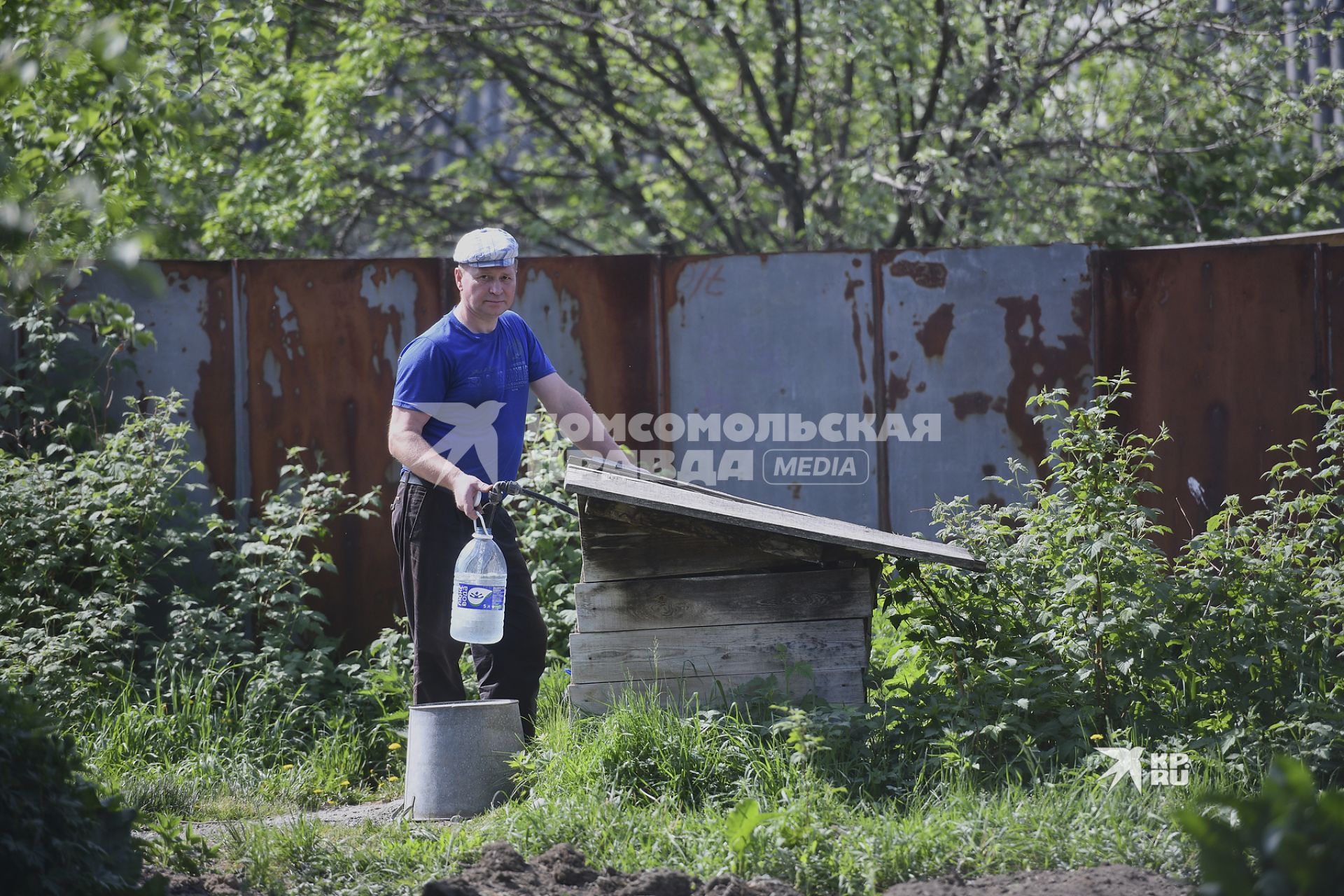 Екатеринбург. Мужчина набирает воду на водной колонке в саду