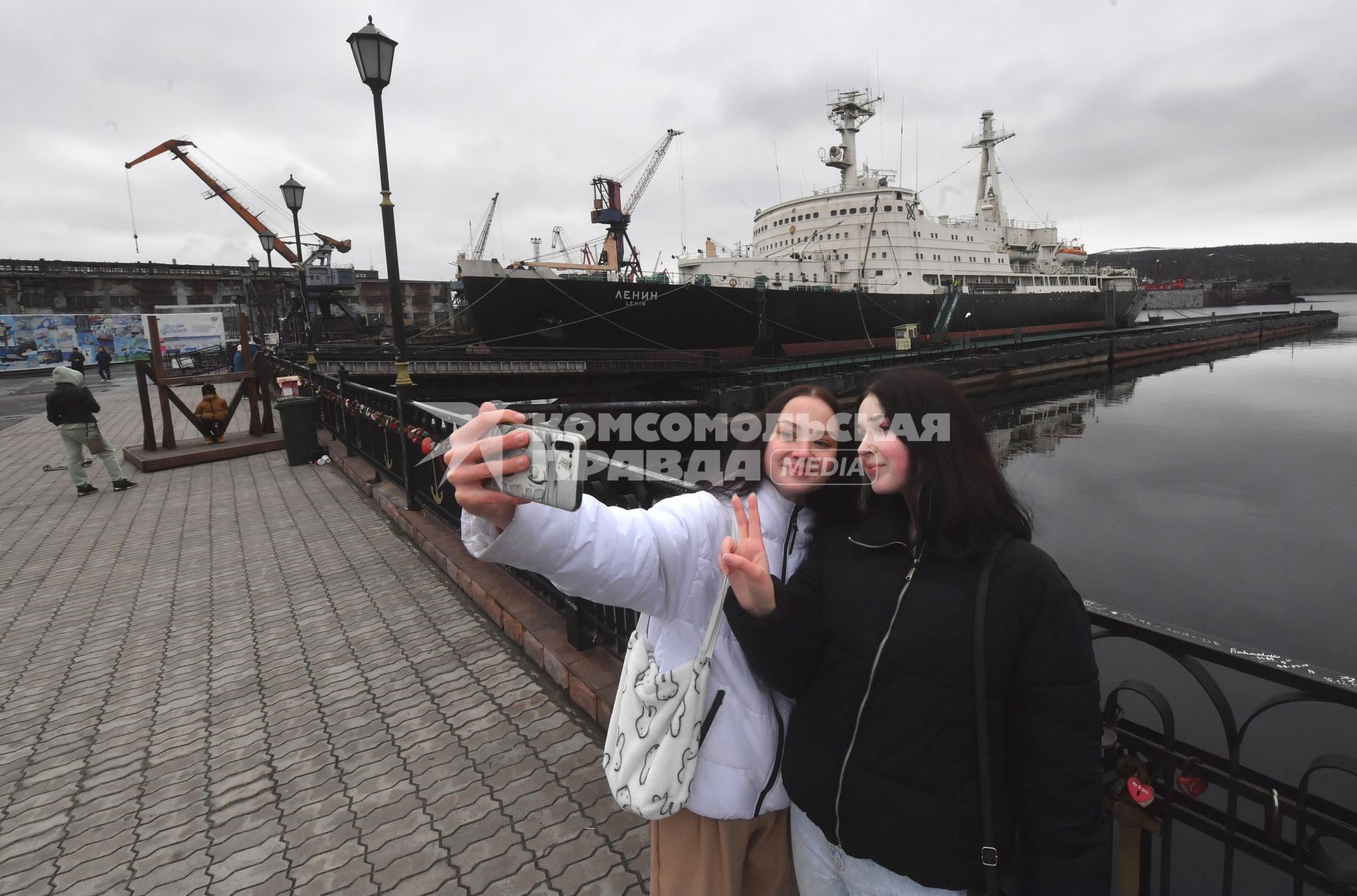 Мурманск. Девушки фотографируются в порту у исторического музей-ледокола `Ленин`в порту.