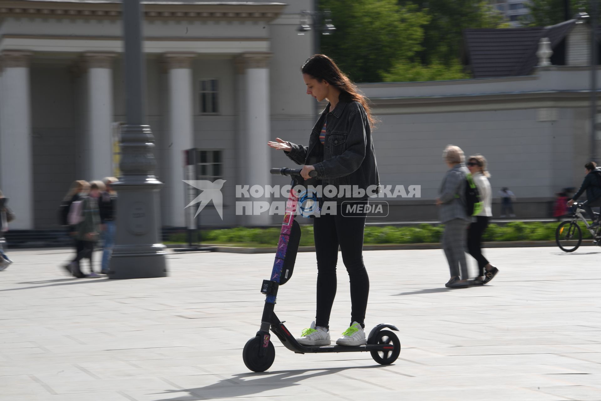 Москва. Девушка едет на электросамокате  на ВДНХ.