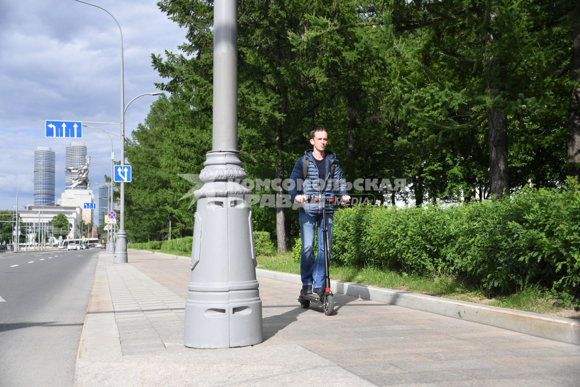 Москва.  Мужчина едет на электросамокате по Проспекту Мира.