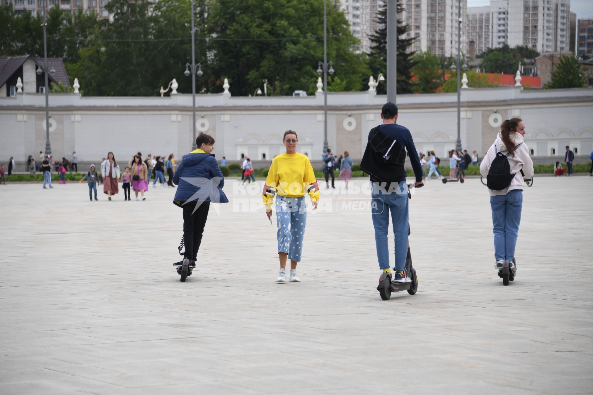 Москва. Молодые люди катаются  на электросамокате  на ВДНХ.