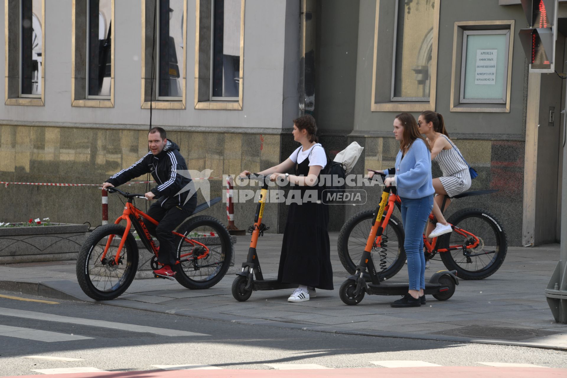 Москва. Горожане на велосипедах и самокатах на улице города.
