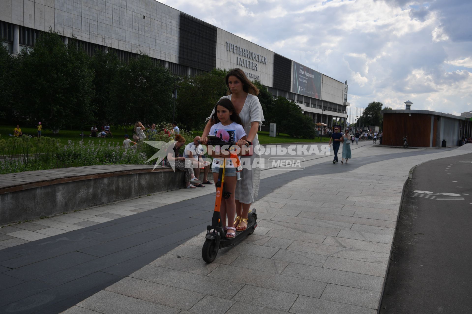 Москва. Женщина с девочкой на самокате в парке `Музеон`.