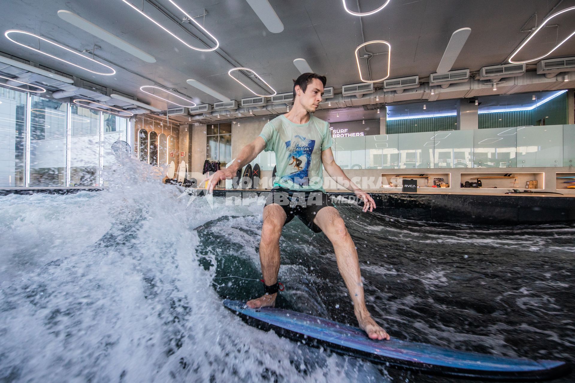 Москва. Молодой человек во время тренировки по серфингу в серфинг-центре `Surf Brothers Сколково` на территории бизнес-центра `Амальтея`.