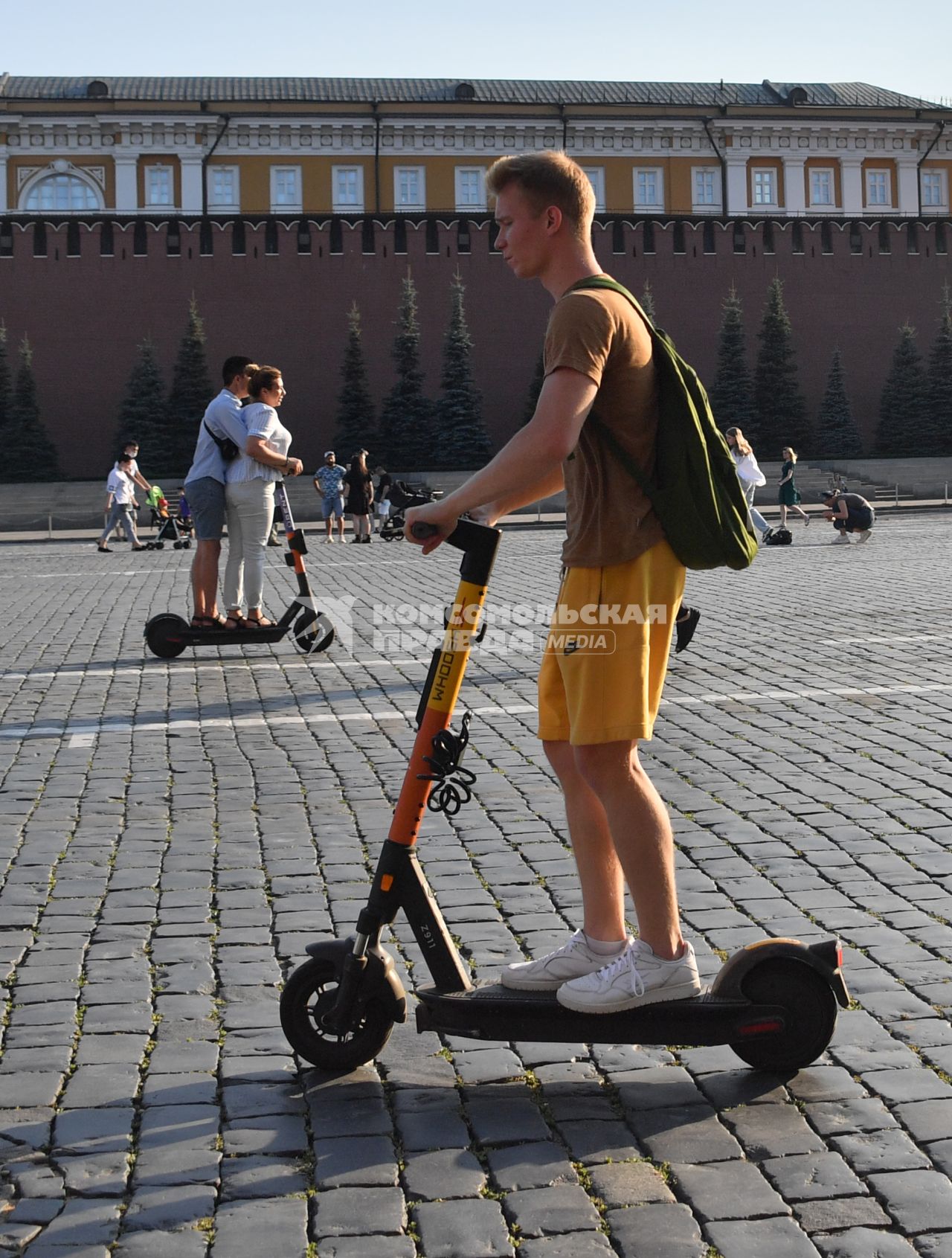 Москва. Молодой человек едет на электросамокате по Красной площади.